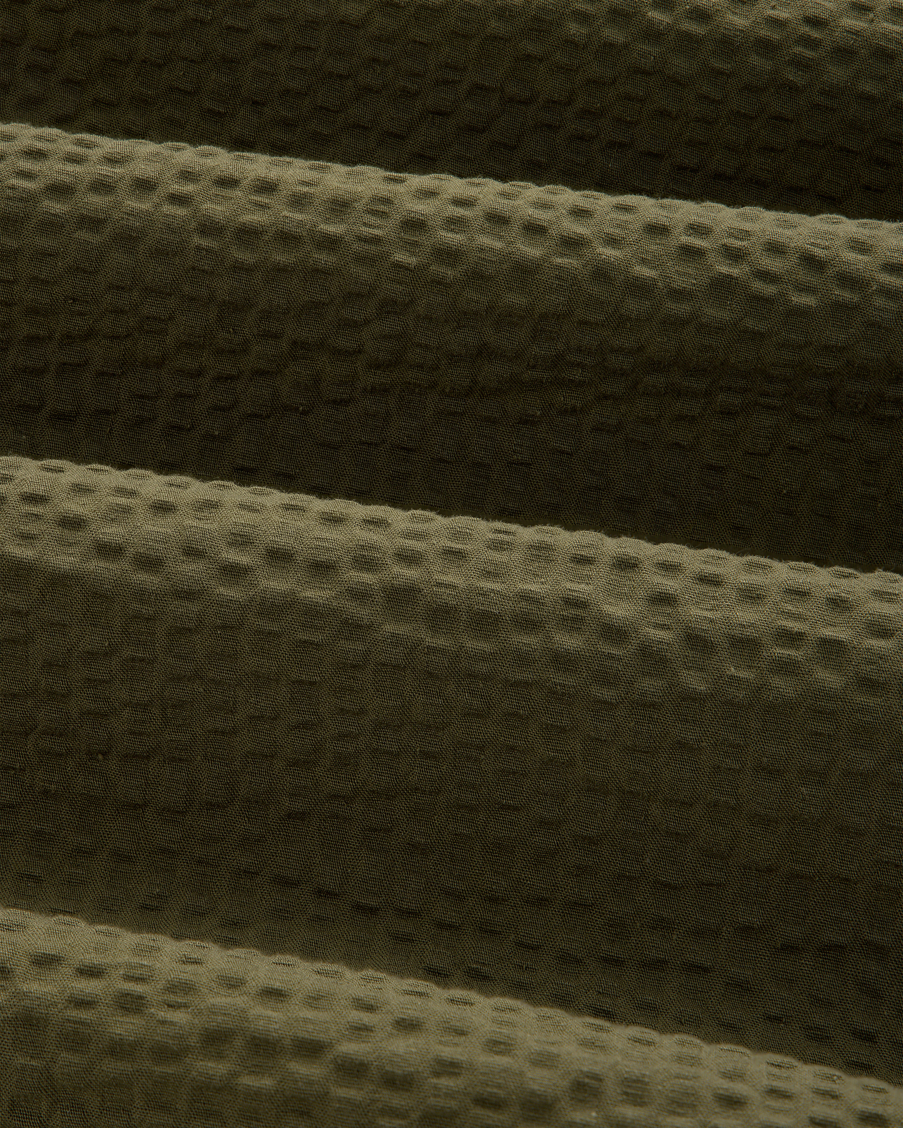 Close-up of olive green seersucker fabric on the Short-Sleeve Seersucker Shirt, highlighting its soft, ridged texture.