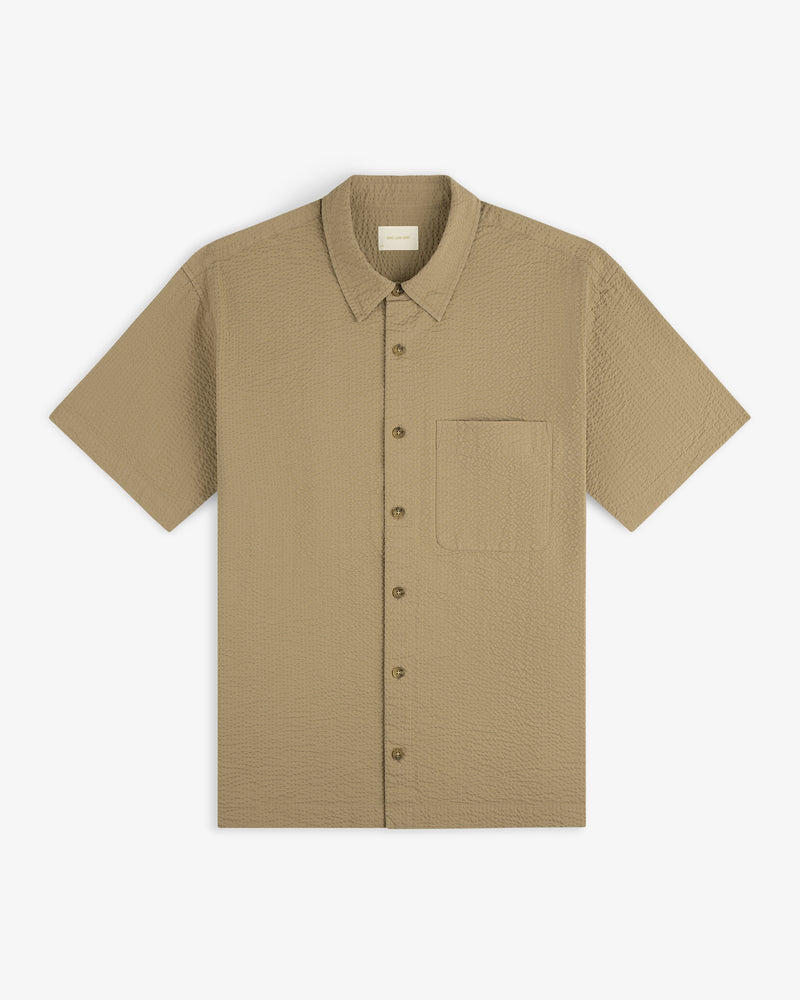Short-Sleeve Seersucker Shirt in light brown with a chest pocket, laid flat on a white background.