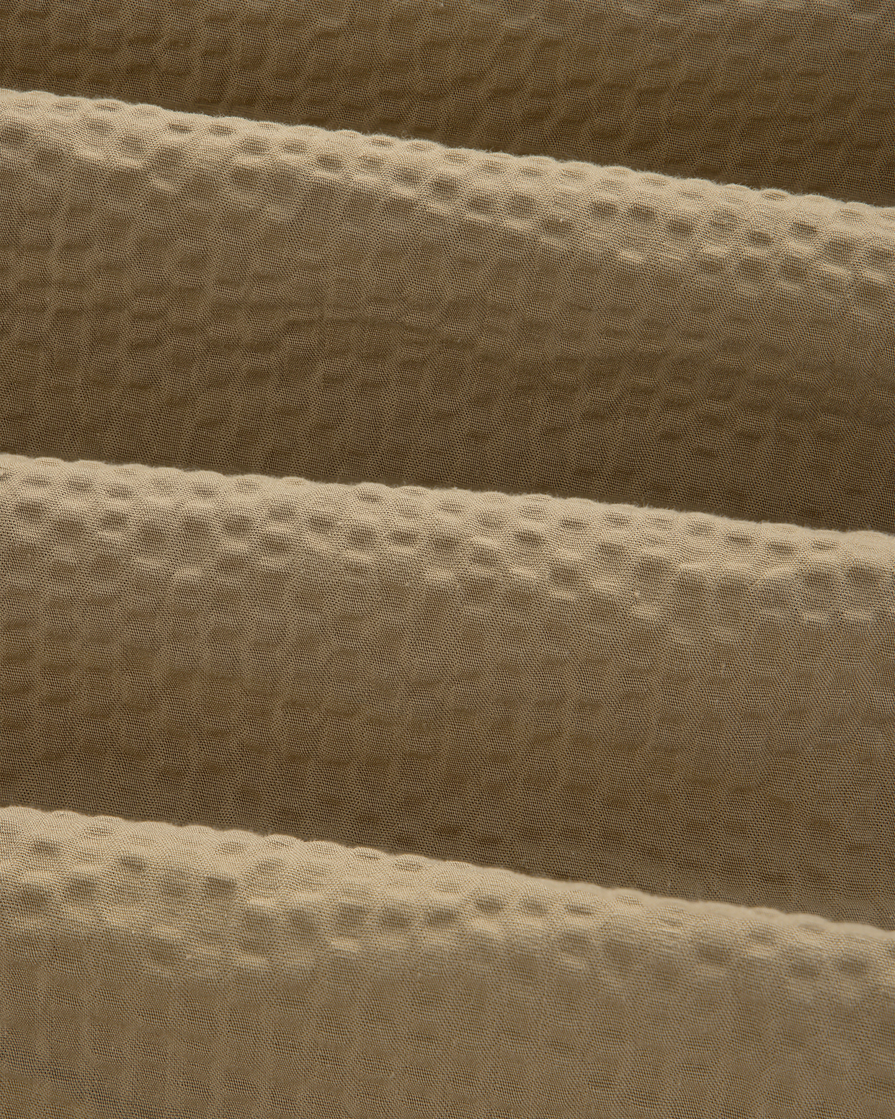 Close-up of the Short-Sleeve Seersucker Shirt's tan fabric, featuring a soft, textured waffle-like pattern.