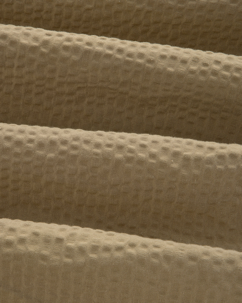 Close-up of the Short-Sleeve Seersucker Shirt's tan fabric, featuring a soft, textured waffle-like pattern.
