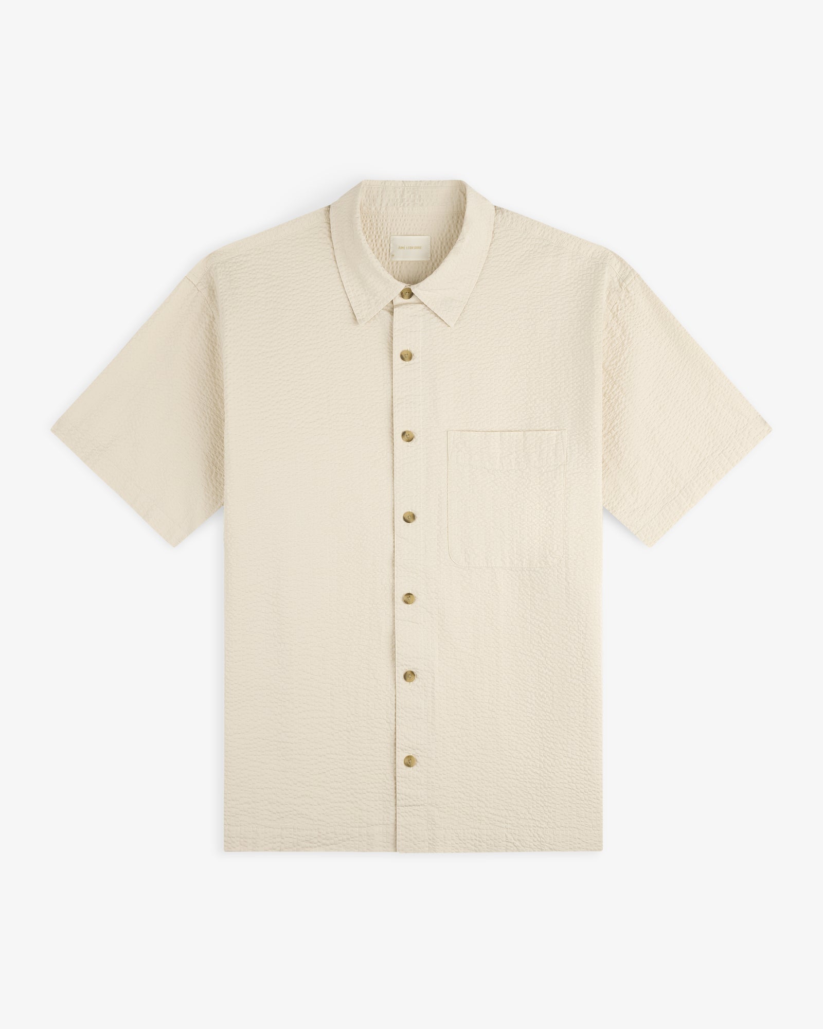 Short-Sleeve Seersucker Shirt in beige with a chest pocket, button-up, shown laid flat on a white background.