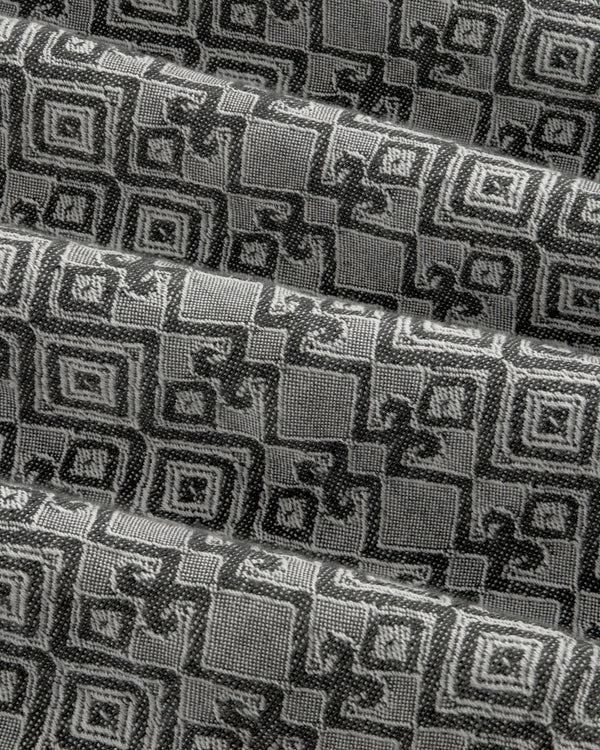 Jacquard Leisure Shirt in black and gray with geometric and floral patterns, shown in pleated diagonal folds.