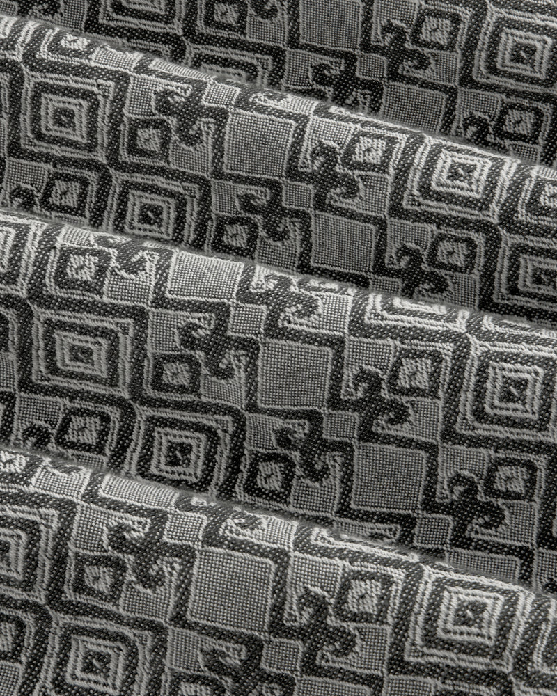 Jacquard Leisure Shirt in black and gray with geometric and floral patterns, shown in pleated diagonal folds.