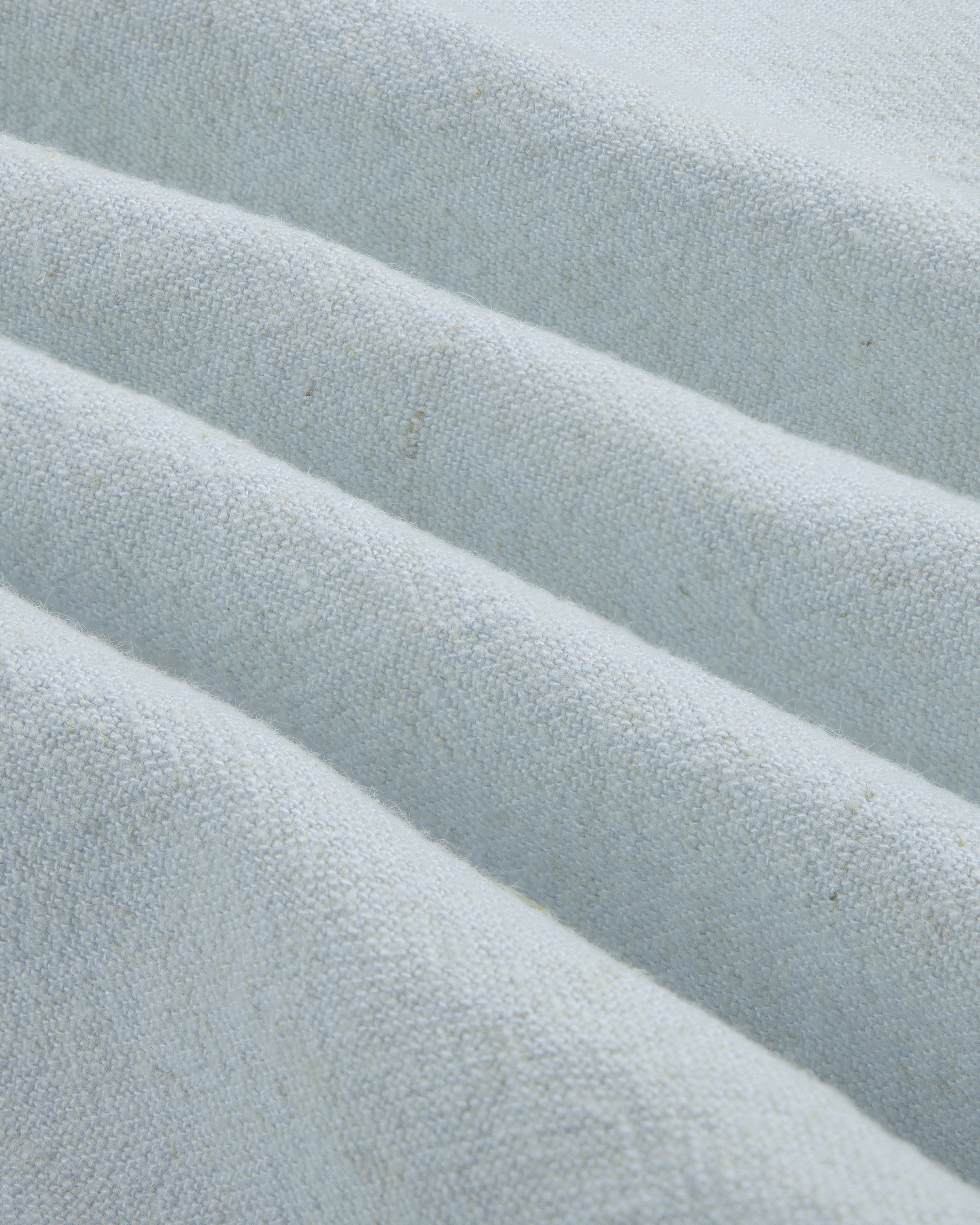 Close-up of the Linen Blend Leisure Shirt in light gray with textured fabric folded into neat, diagonal pleats.