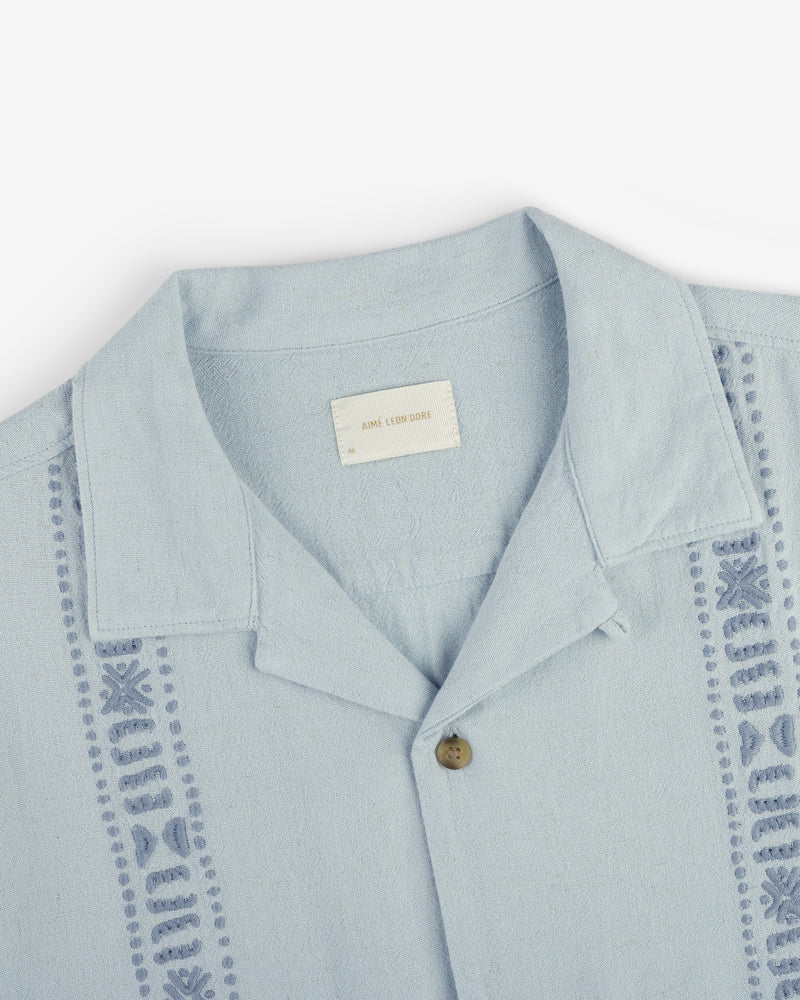 Linen Blend Leisure Shirt in light blue with decorative stitching and a single brown button, laid flat on white.