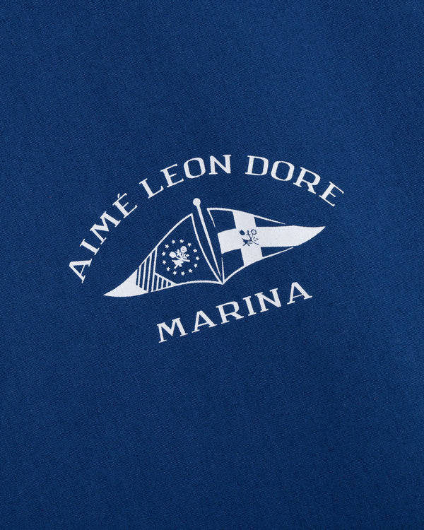 White Aimé Leon Dore Marina text and nautical flag logos printed on blue Marina Jacket fabric.
