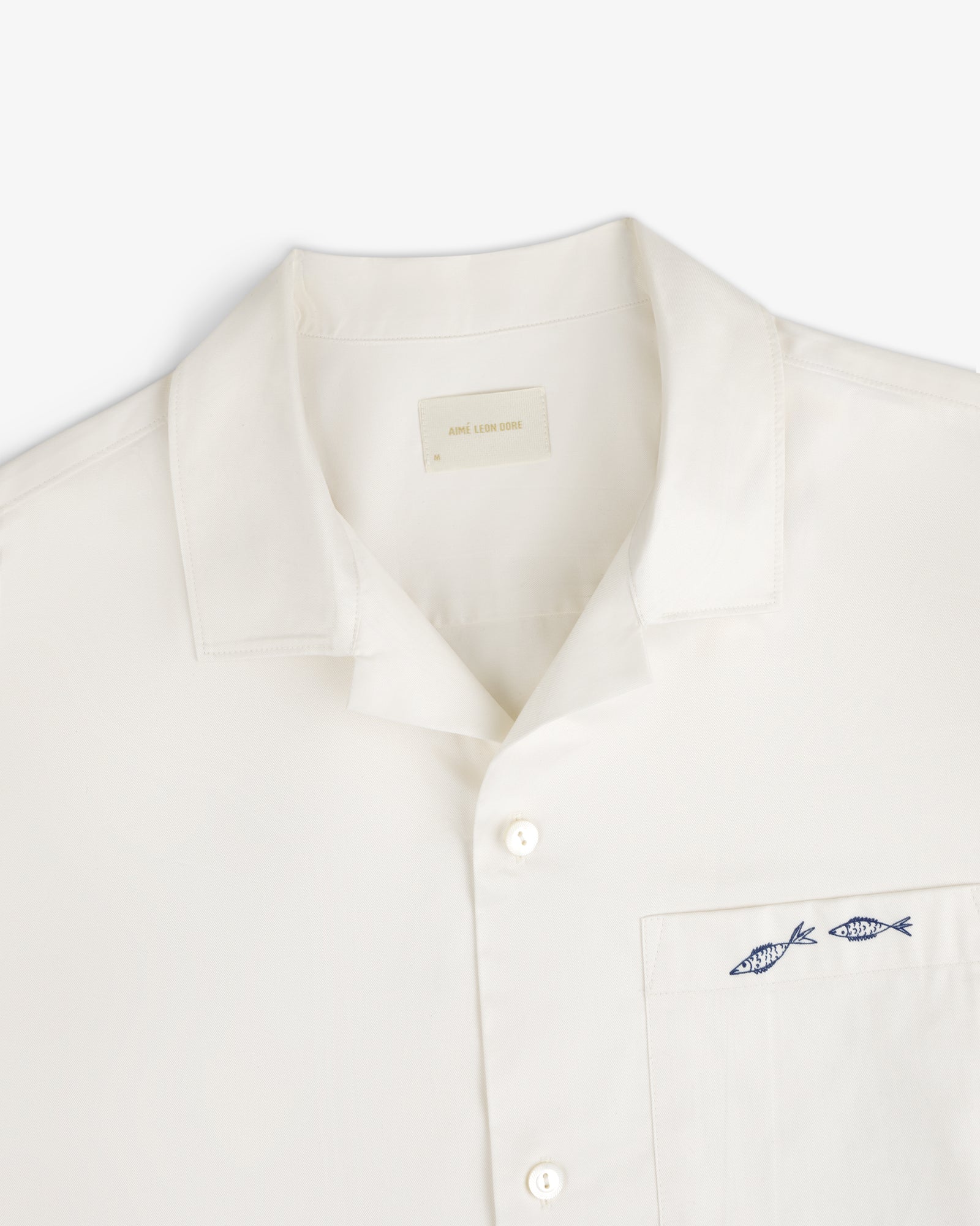 Fassianos "Rendez - Vous" Camp Shirt: White shirt with collar, pocket, and two blue fish embroidered above the pocket.