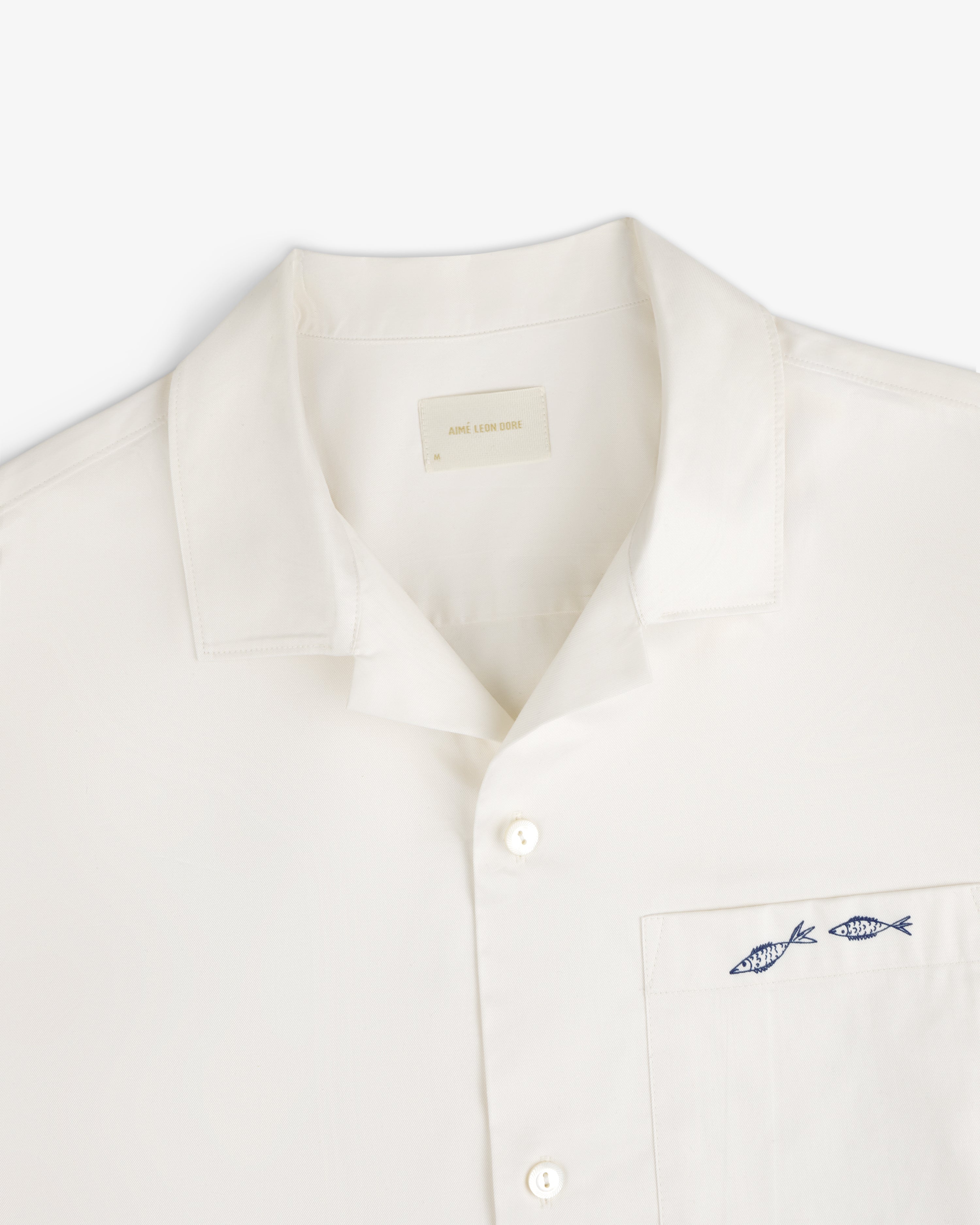 Fassianos "Rendez - Vous" Camp Shirt: White shirt with collar, pocket, and two blue fish embroidered above the pocket.