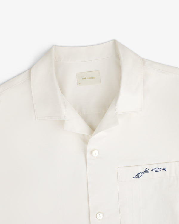 Fassianos "Rendez - Vous" Camp Shirt: White shirt with collar, pocket, and two blue fish embroidered above the pocket.