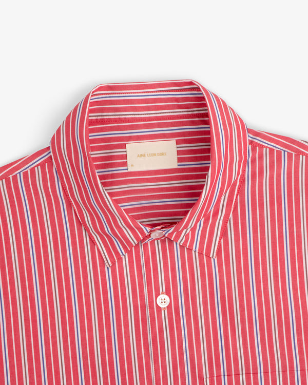 Aimé Leon Dore Yarn Dyed Striped Shirt with red, blue, and white stripes, spread collar, and branded label.