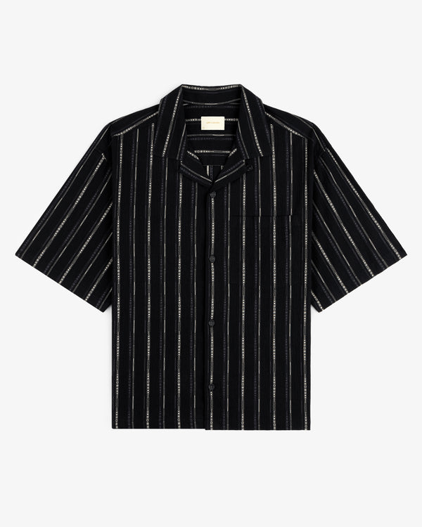Cropped Jacquard Camp Shirt in black with vertical white stripes and a chest pocket, laid flat on white background.