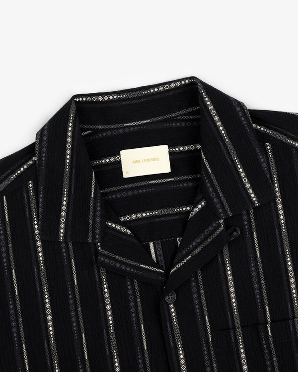 Cropped Jacquard Camp Shirt: black with vertical white and gray geometric stripes, top buttoned, label inside visible.