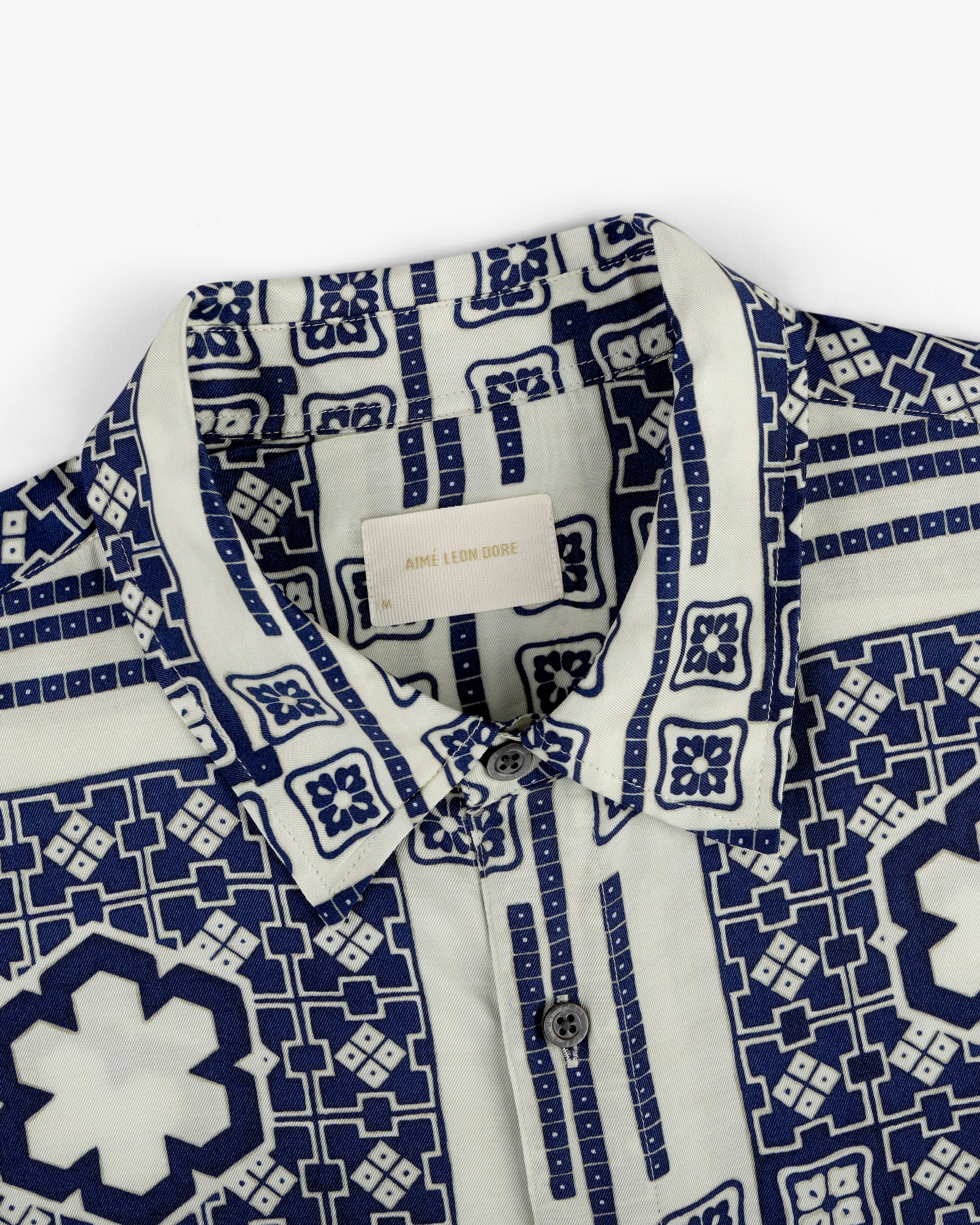 Close-up of the Mosaic Button Down Shirt featuring a blue geometric and floral pattern on a white background.