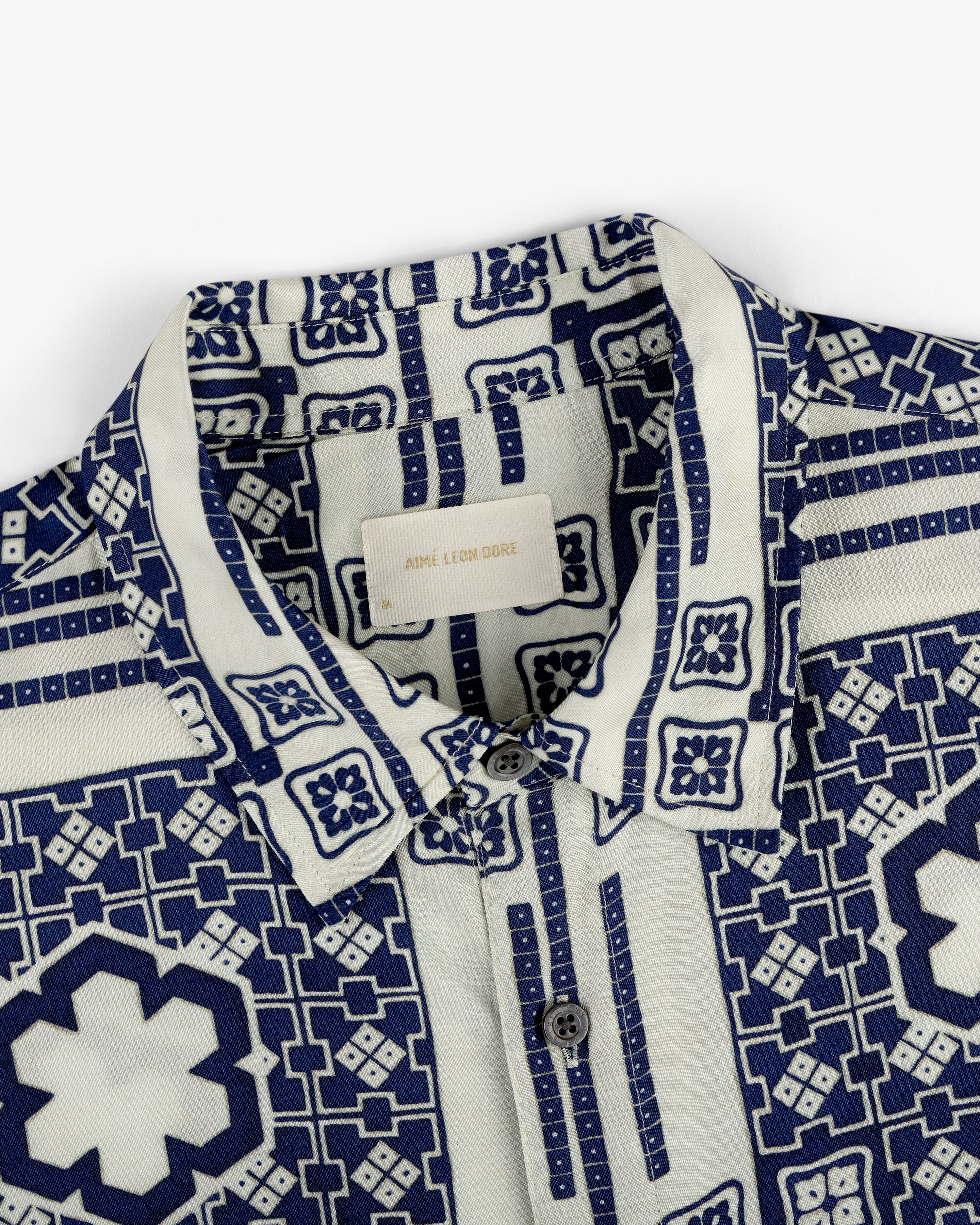 Close-up of the Mosaic Button Down Shirt featuring a blue geometric and floral pattern on a white background.