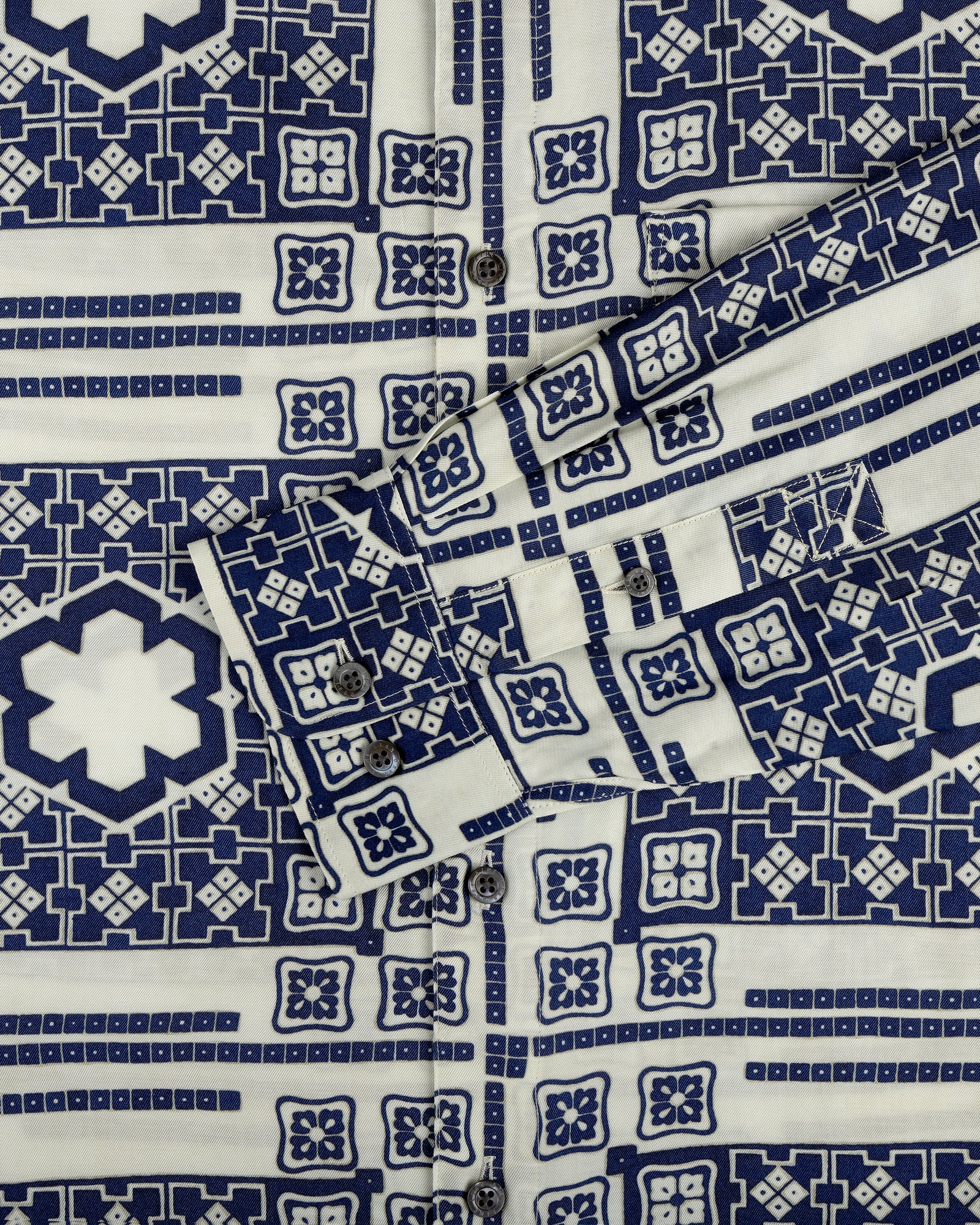 A close-up of the Mosaic Button Down Shirt featuring blue and white geometric patterns and visible buttons.