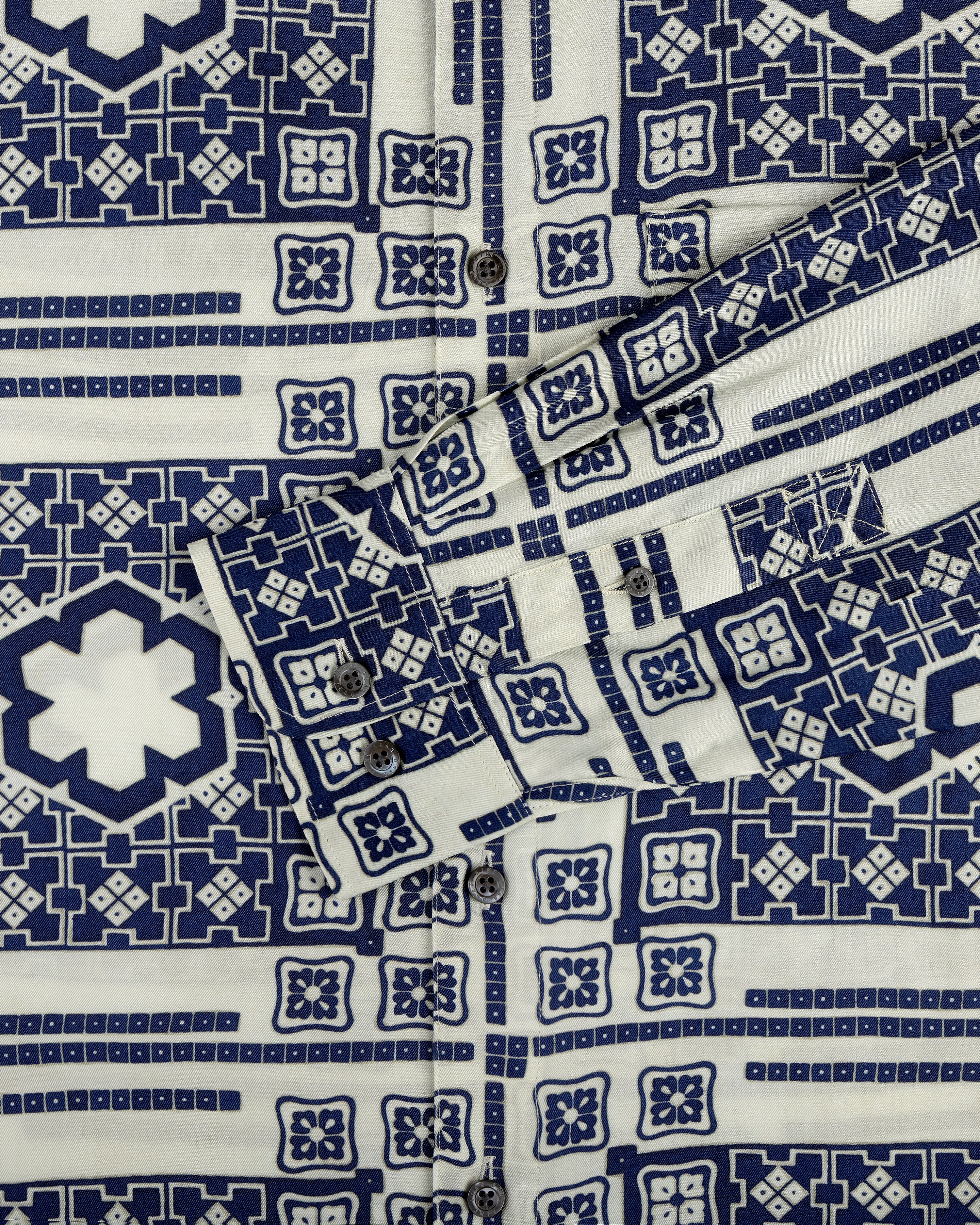 A close-up of the Mosaic Button Down Shirt featuring blue and white geometric patterns and visible buttons.