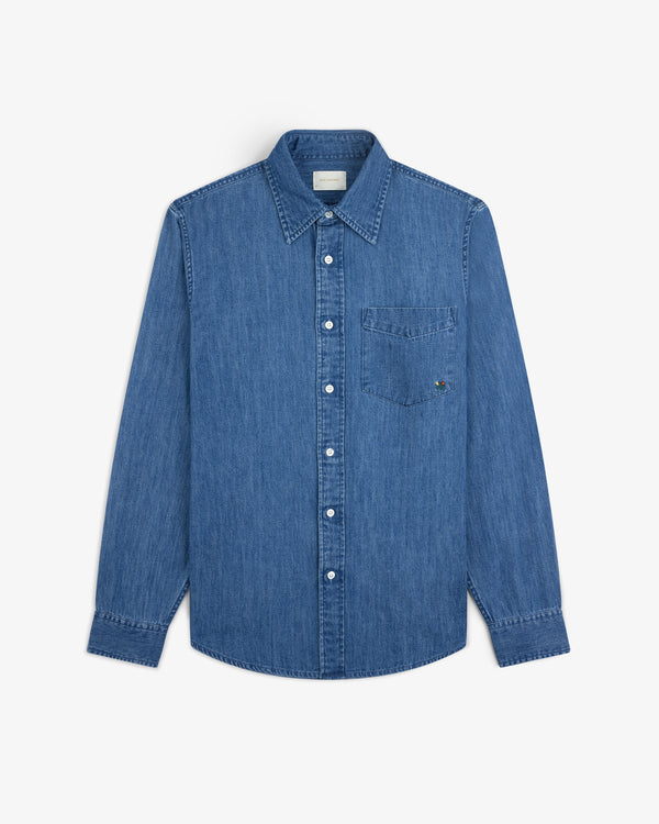 Crest Chambray Shirt: long-sleeve blue denim button-up with collar and chest pocket, laid flat on white background.