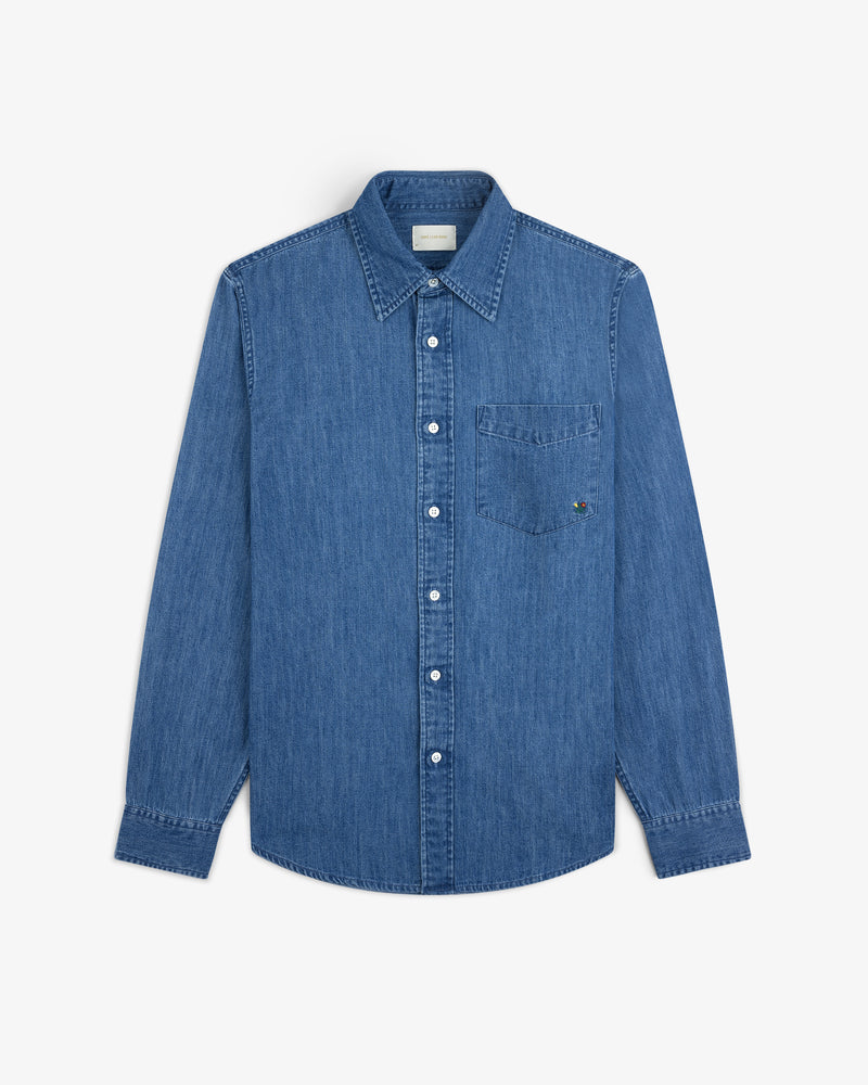 Crest Chambray Shirt: long-sleeve blue denim button-up with collar and chest pocket, laid flat on white background.