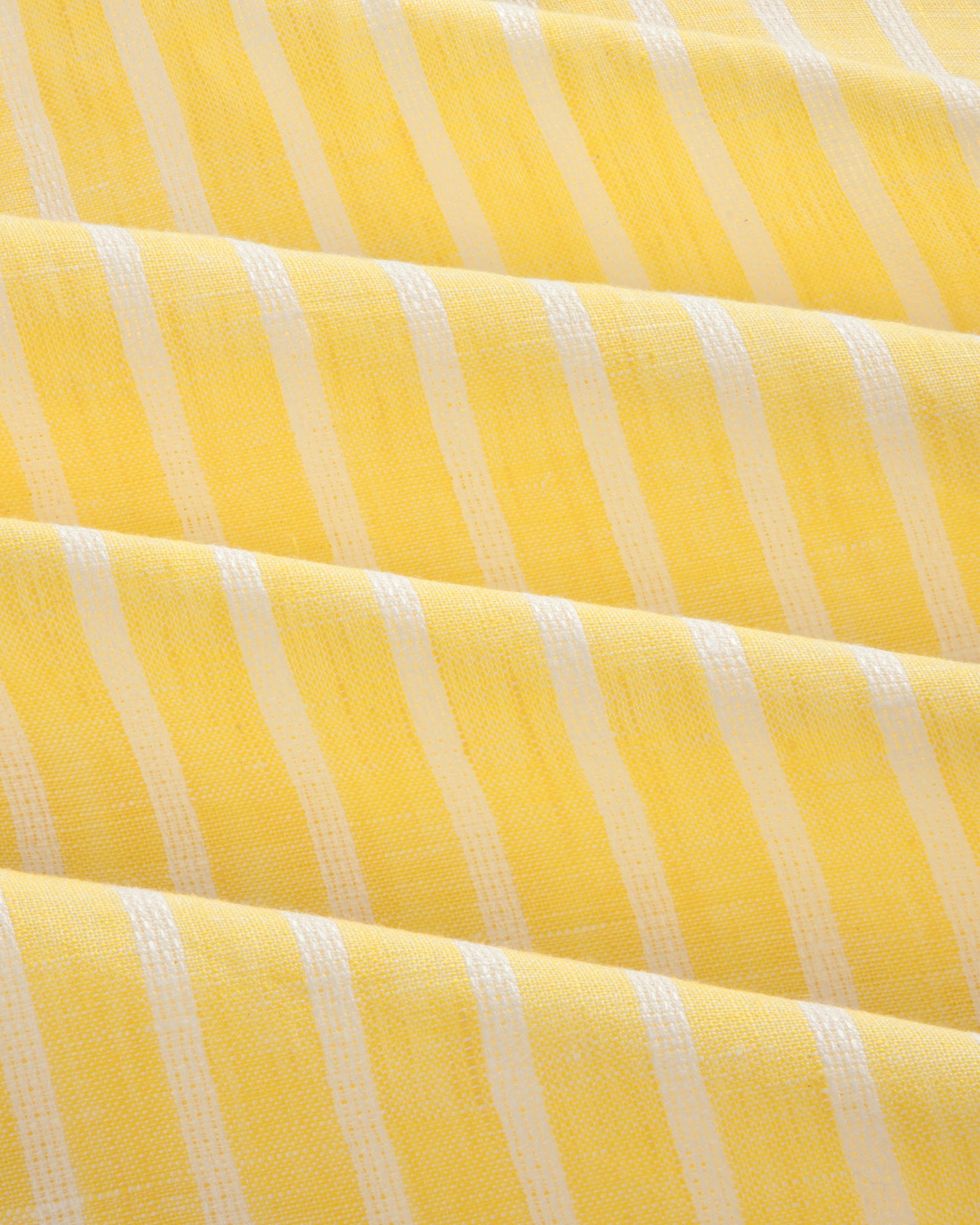 Yellow striped linen casual shirt with white vertical stripes and soft, even folds across the fabric.