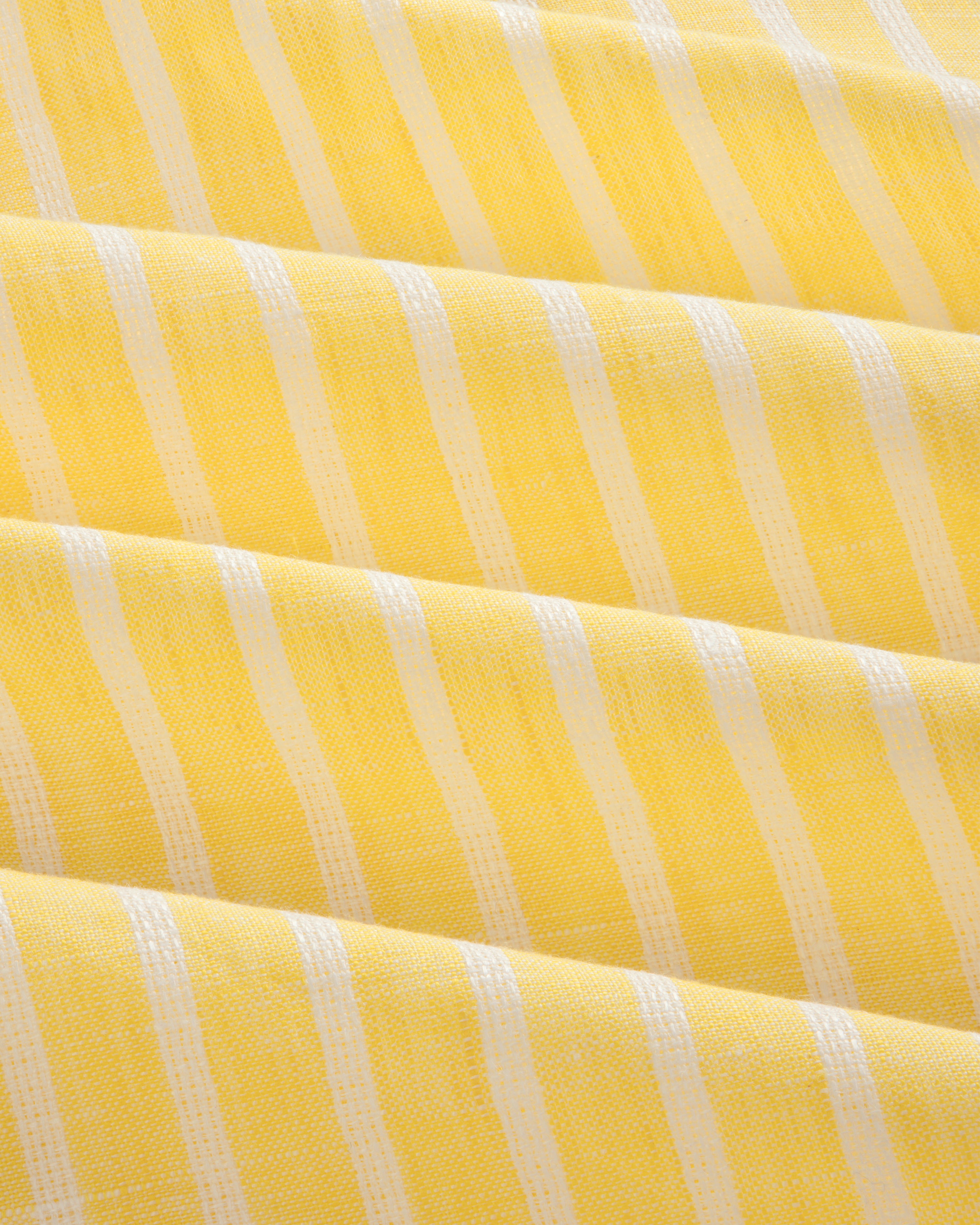 Yellow striped linen casual shirt with white vertical stripes and soft, even folds across the fabric.