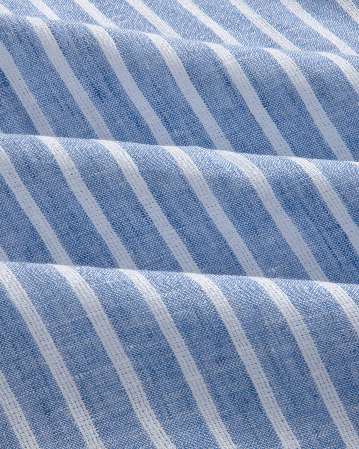 Close-up of the Striped Linen Casual Shirt in light blue, featuring vertical white stripes and a textured surface.
