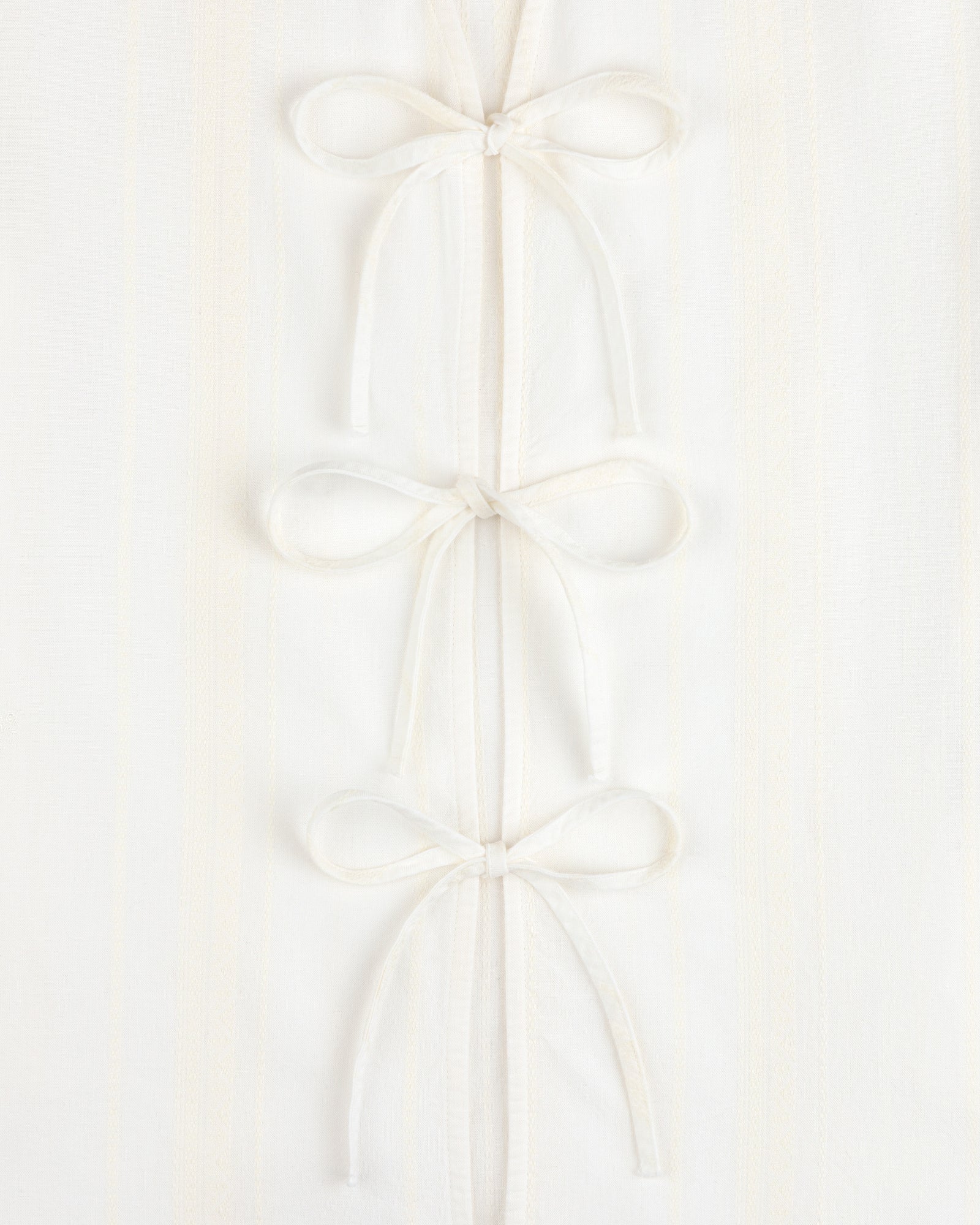 Three Jacquard Striped Tie-Front Shirts are stacked vertically on a white textured background.