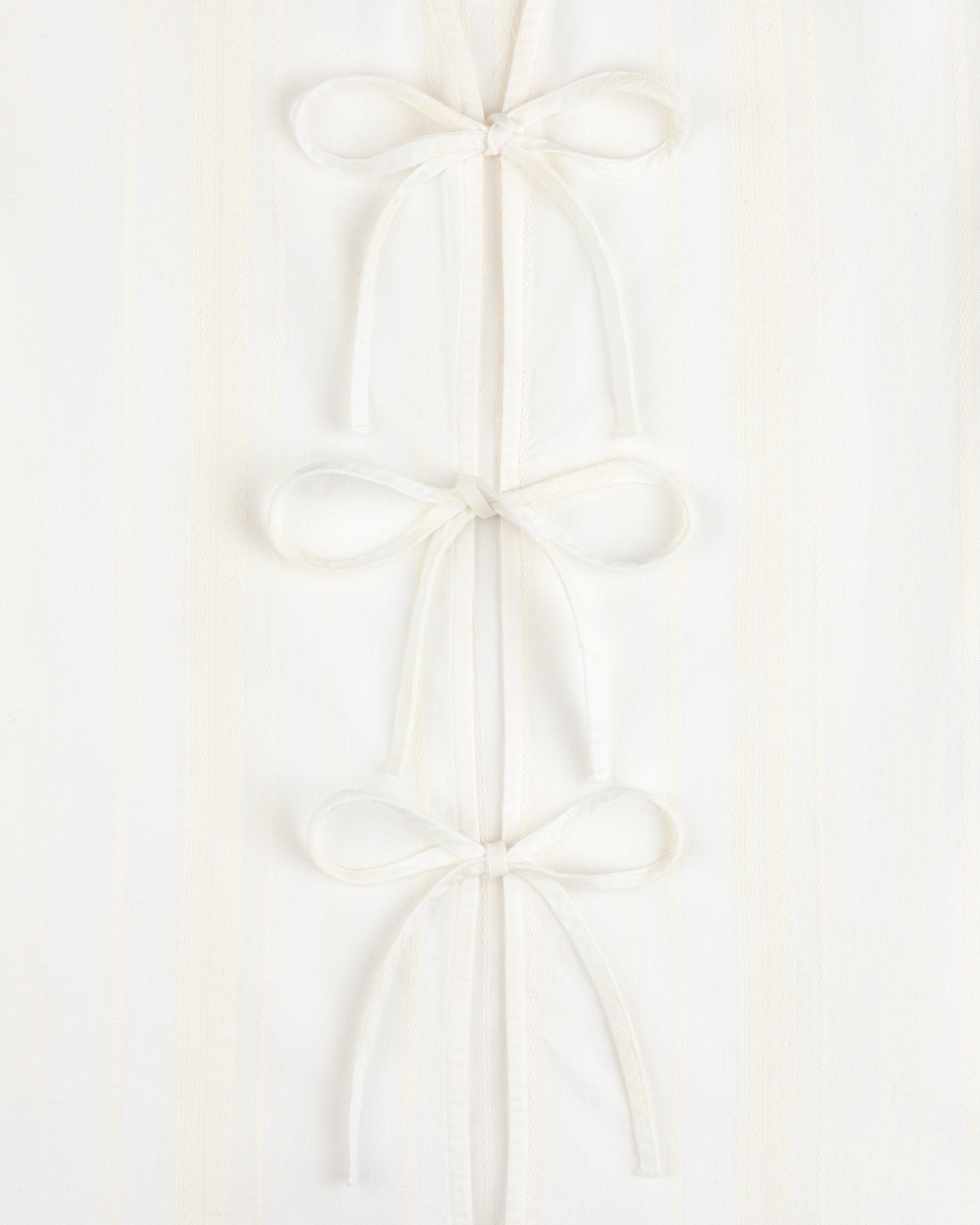 Three Jacquard Striped Tie-Front Shirts are stacked vertically on a white textured background.