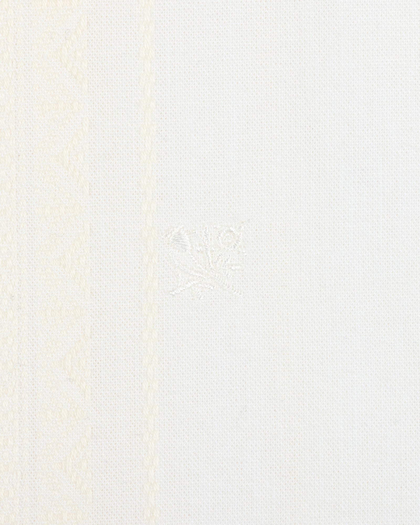 Close-up of the Jacquard Striped Tie-Front Shirt's white textured fabric with subtle patterns and a central embroidered detail.
