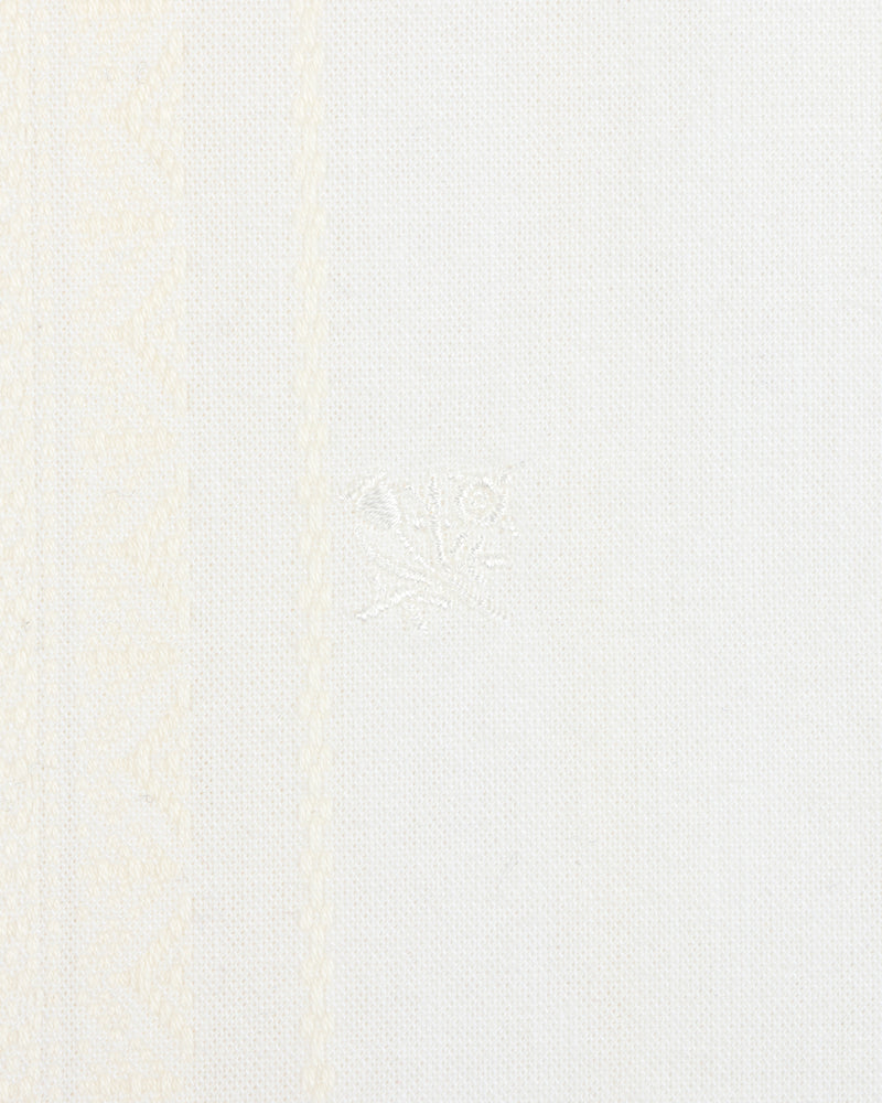 Close-up of the Jacquard Striped Tie-Front Shirt's white textured fabric with subtle patterns and a central embroidered detail.