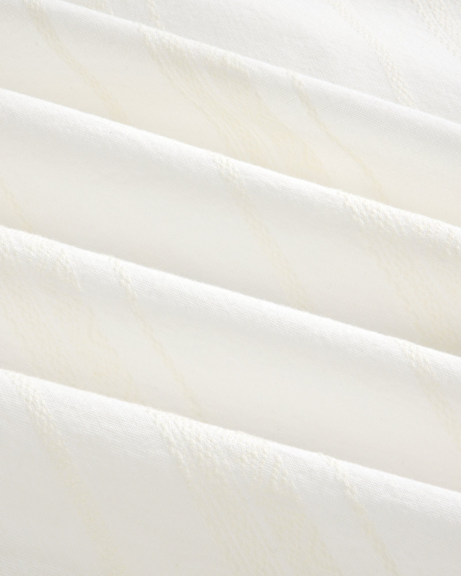 Close-up of Jacquard Striped Tie-Front Shirt showing folded white fabric with subtle diagonal textured lines.