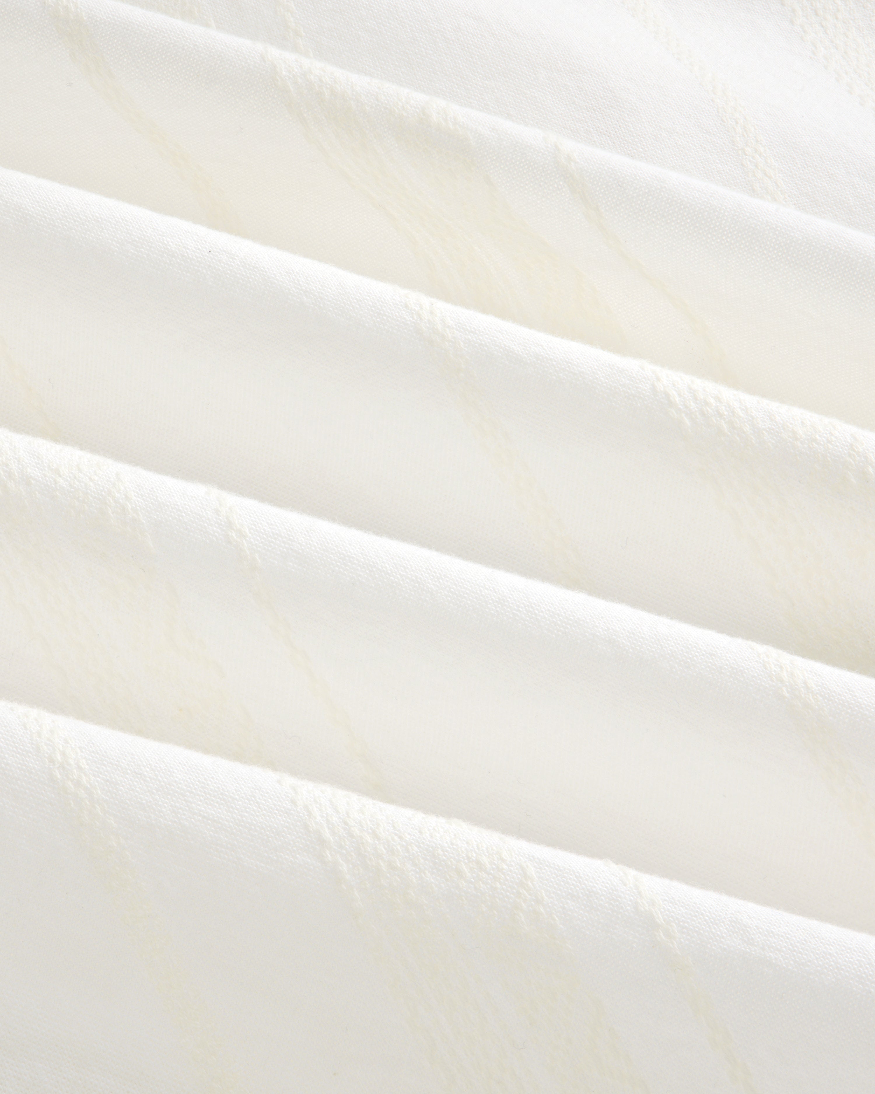 Close-up of Jacquard Striped Tie-Front Shirt showing folded white fabric with subtle diagonal textured lines.