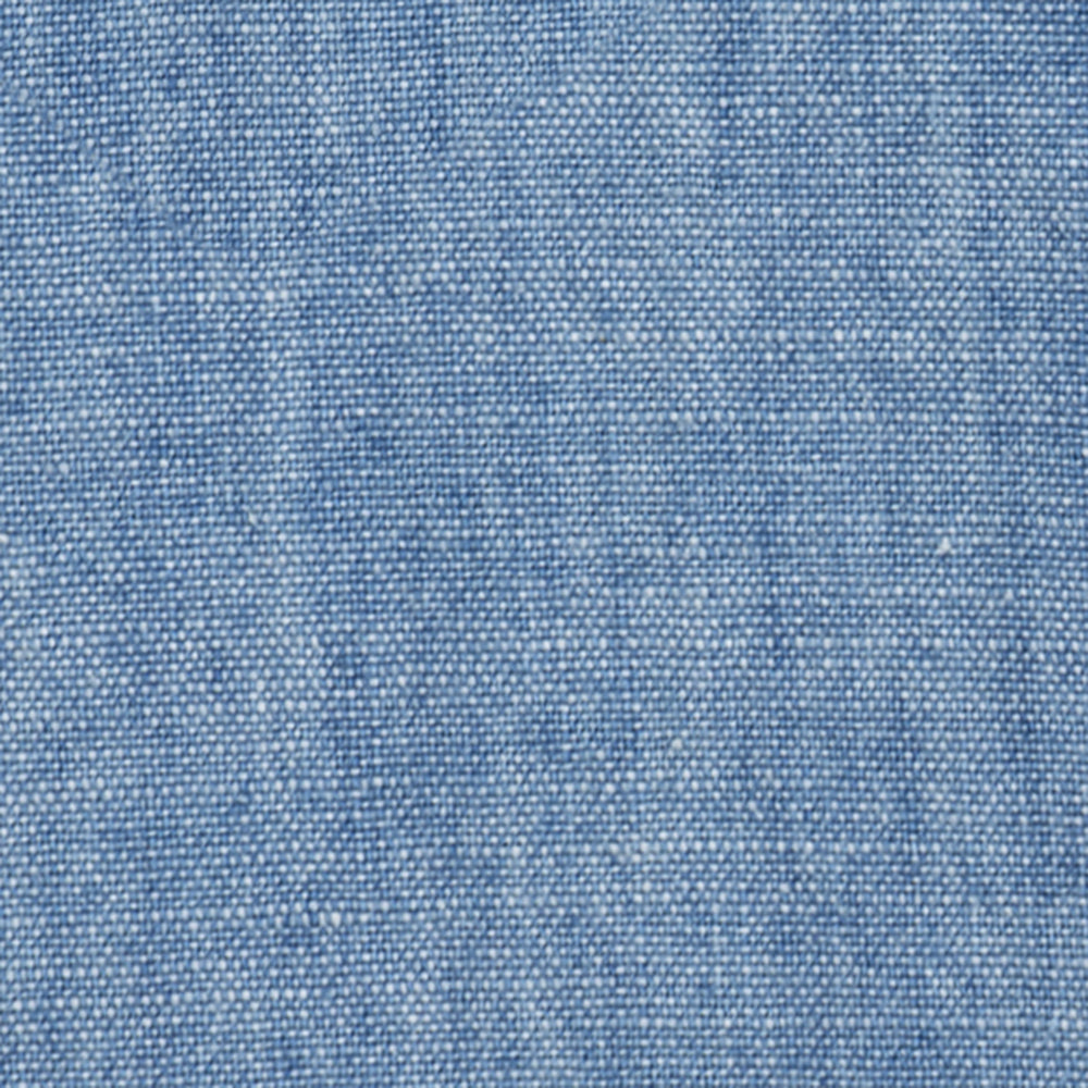 Close-up of Crest Chambray Shirt's blue fabric highlighting its woven texture and fine threads.