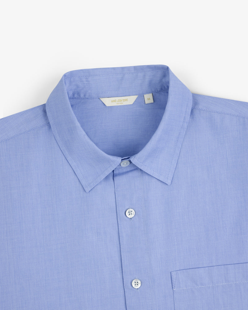 Poplin Casual Shirt in light blue with collar and chest pocket, shown on a white background.