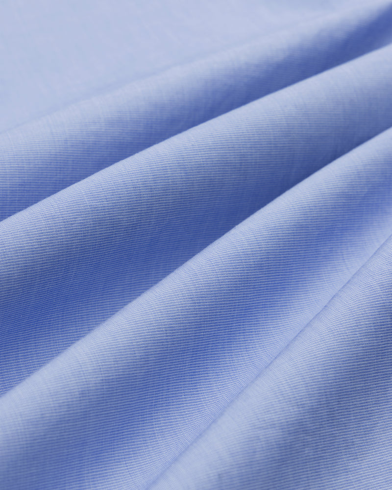 Close-up of Poplin Casual Shirt in light blue, showing soft folds and fine weave texture.