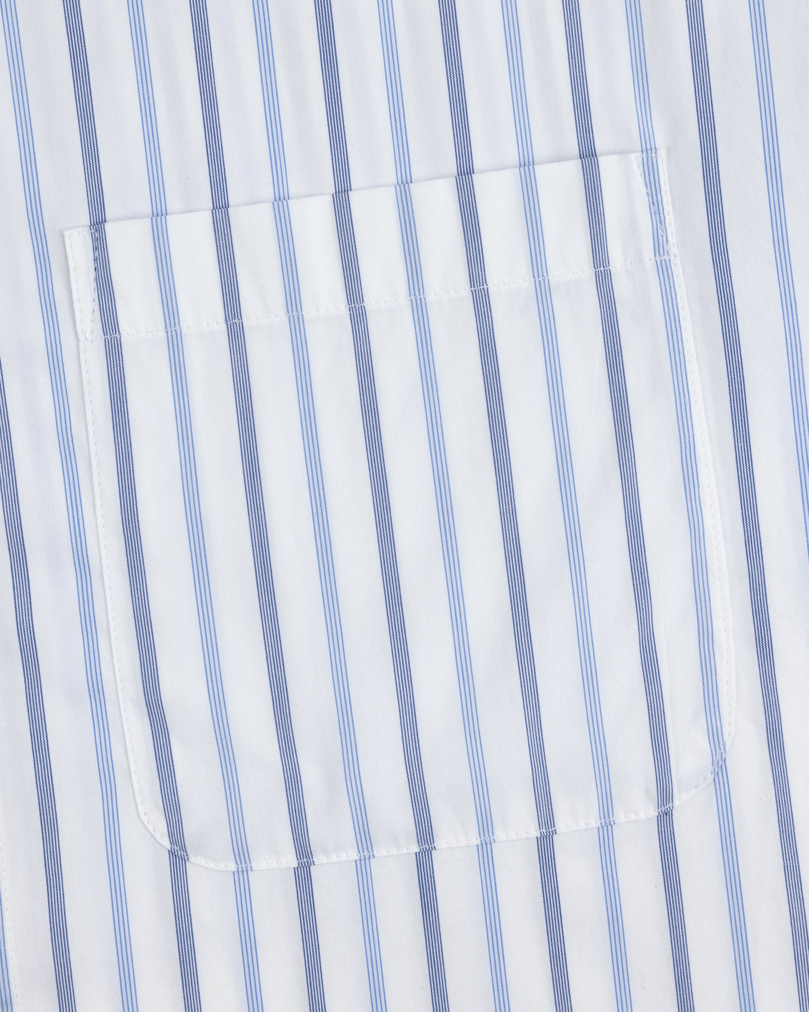 Close-up of Poplin Casual Shirt pocket on white fabric with vertical blue and light blue stripes.