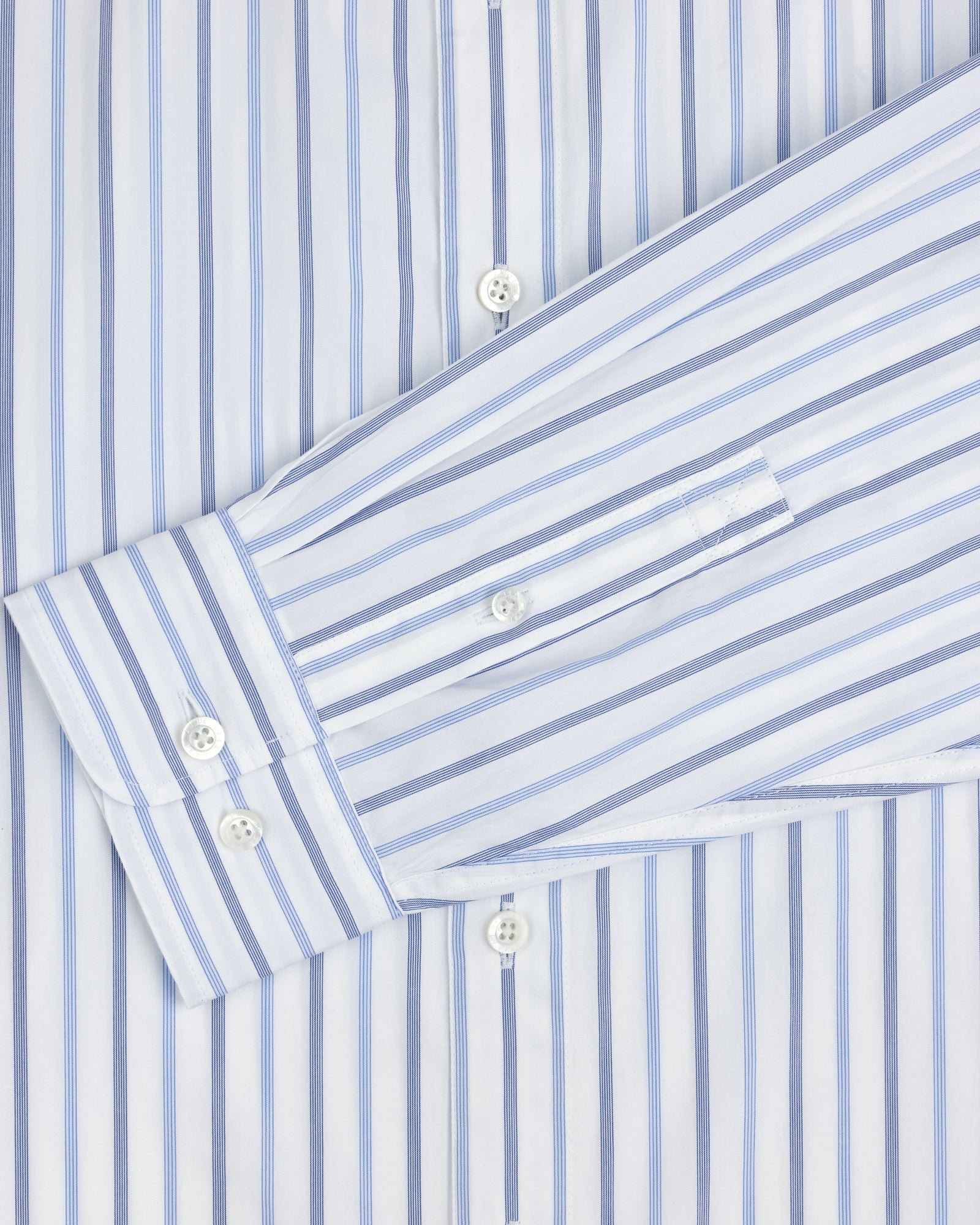 Close-up of a Poplin Casual Shirt featuring blue vertical stripes and white buttons on the cuff and front placket.