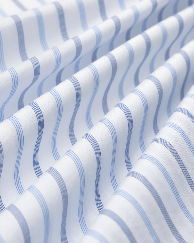 Close-up of Poplin Casual Shirt: white fabric with wavy blue stripes, gentle folds, and soft texture.