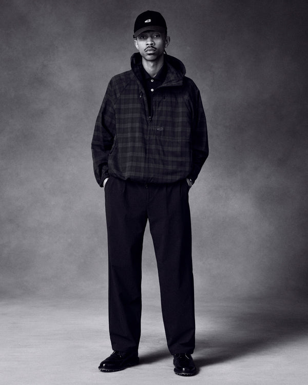 A man wears the ALD Golf Lightweight Tips Windbreaker, black cap, and black pants, standing against a gray background.