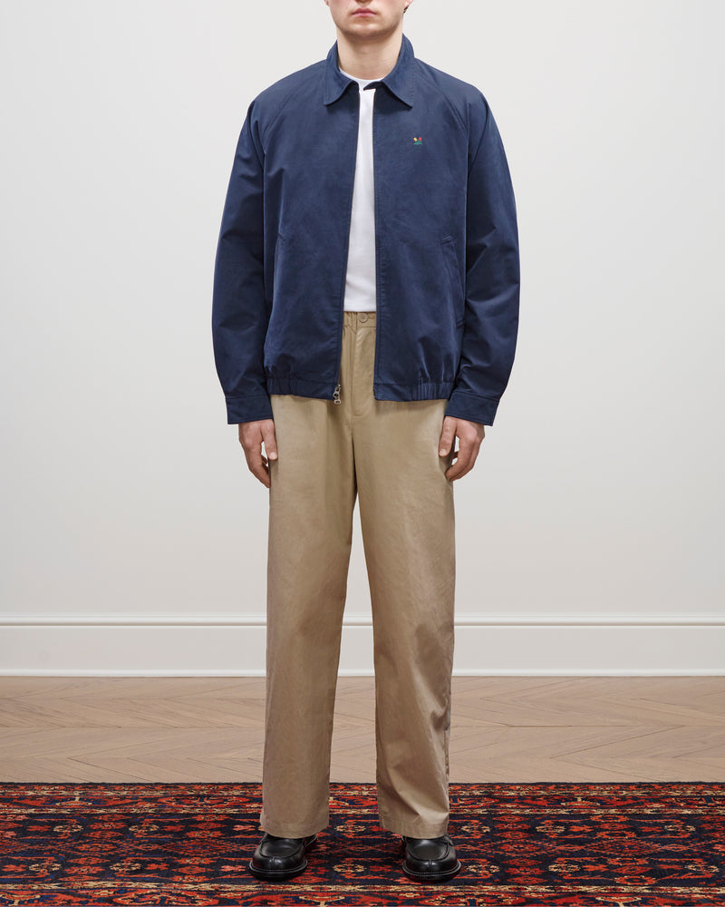 Person wearing a Crest Casual Jacket, white shirt, beige pants, and black shoes stands on a patterned rug.