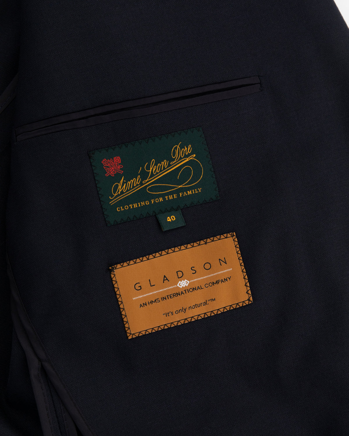 Close-up of Tropical Wool Suit Jacket interior with Aimé Leon Dore and Gladson labels on dark fabric lining.