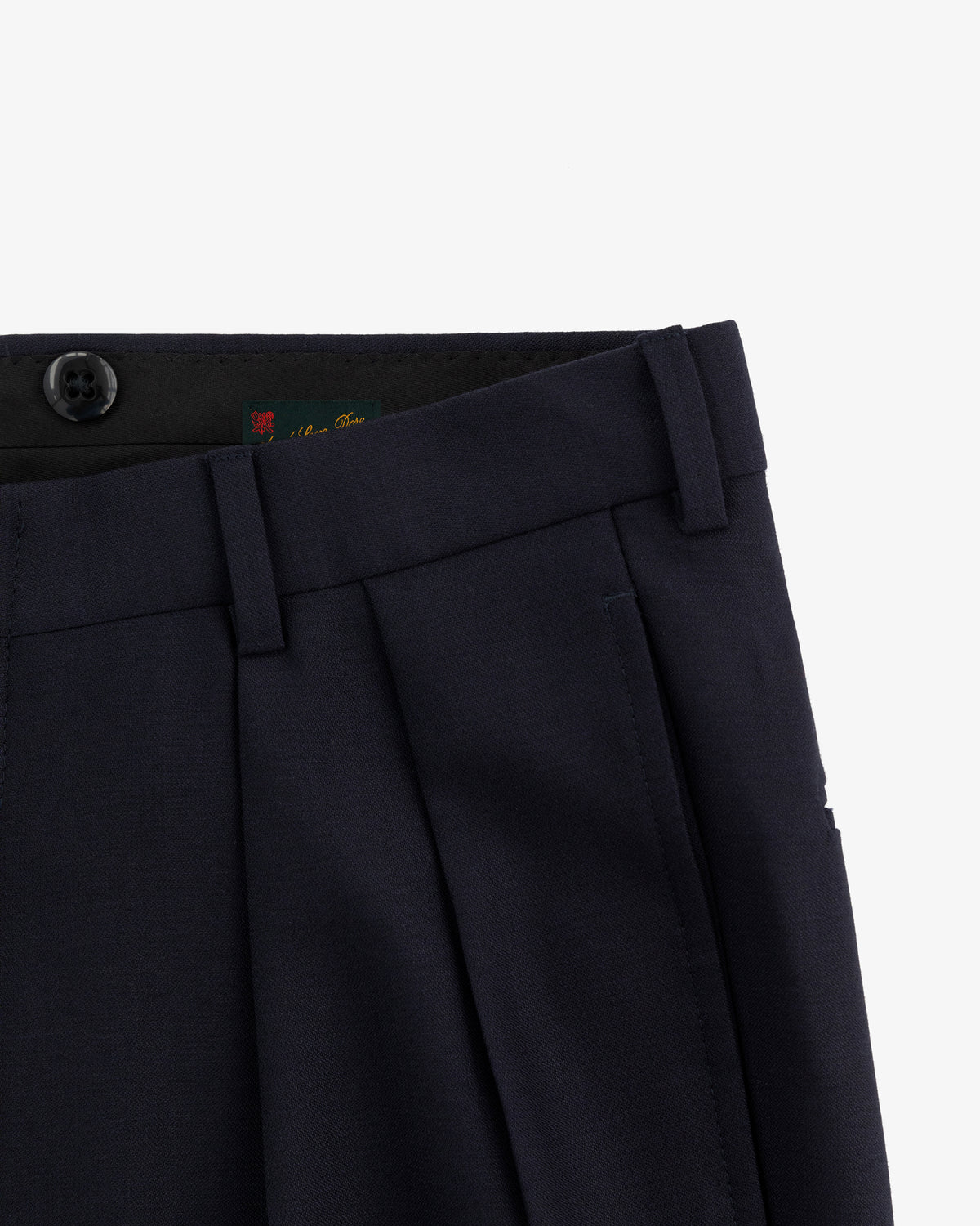 Close-up of the waistband and upper leg of Tropical Wool Suit Trouser in dark navy with pleats, button, and belt loops.