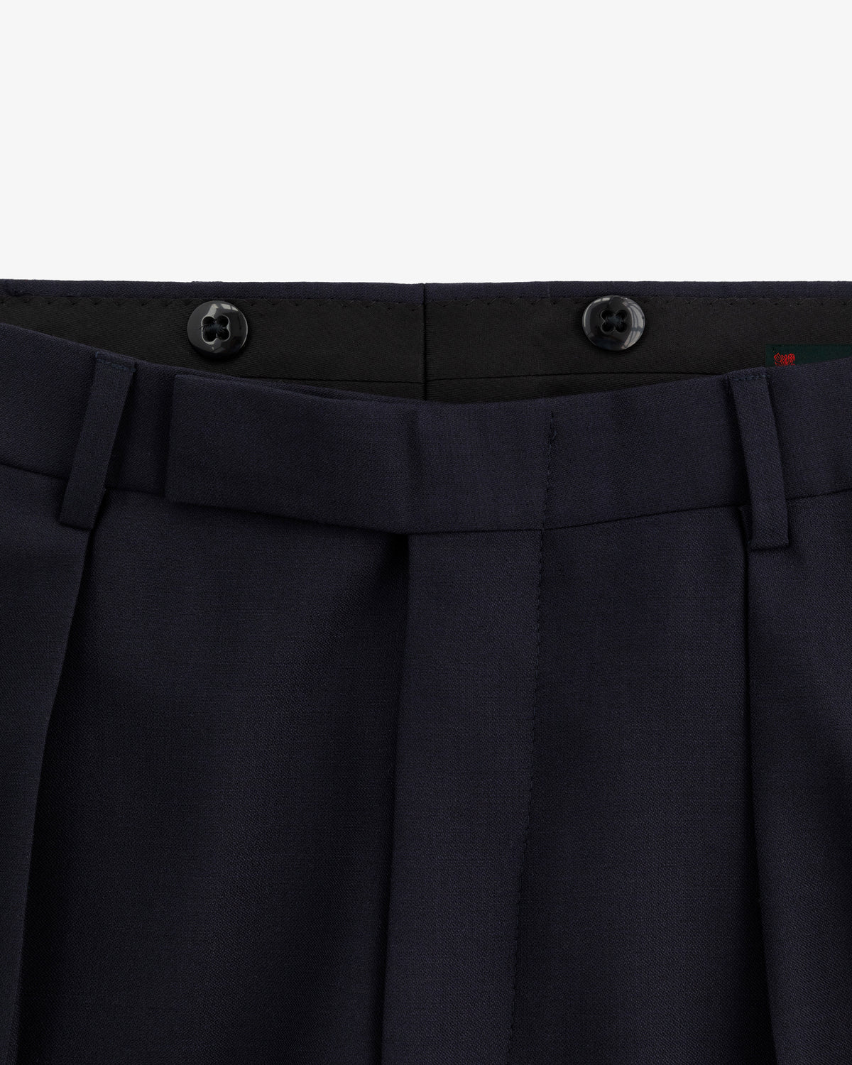 Close-up of the waistband and pleats of Tropical Wool Suit Trouser in dark navy with black inner waistband buttons.