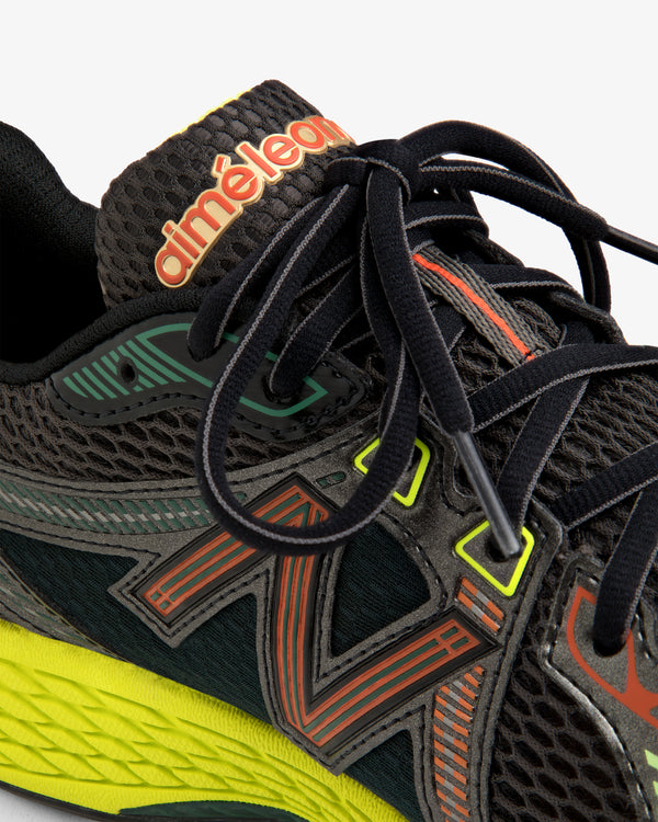 Close-up of the ALD / New Balance 860v2 black sneaker with colorful accents, mesh texture, and branded tongue.