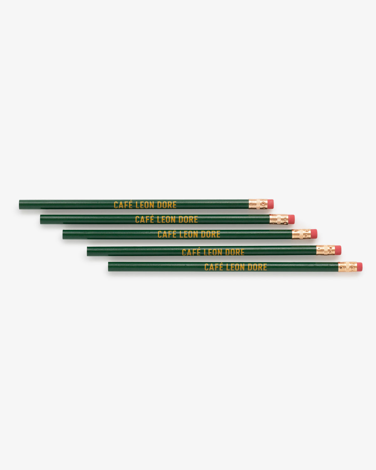 Five green Café Leon Dore pencils with pink erasers, gold branding, arranged in a staggered stack.