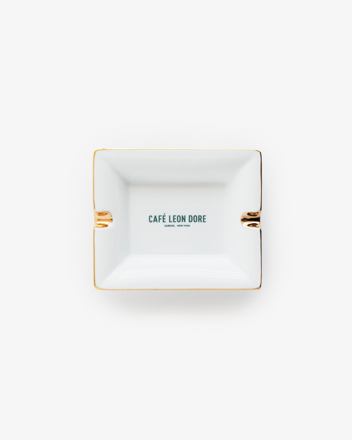 Café Leon Dore Ashtray—rectangular, white with gold trim and green CAFÉ LEON DORE printed at the center.