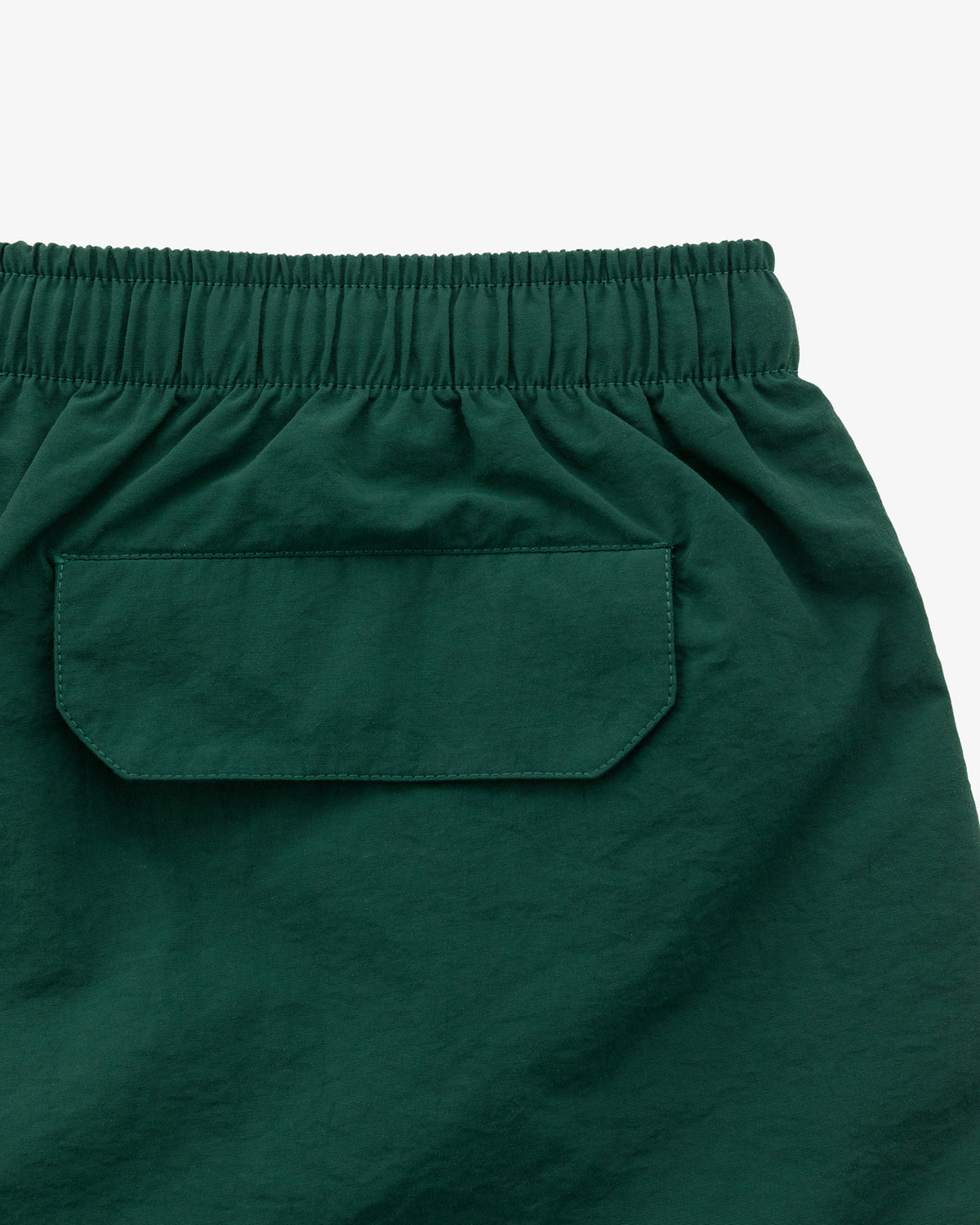Logo Swim Short in dark green with an elastic waistband and a flap back pocket, displayed on a white background.