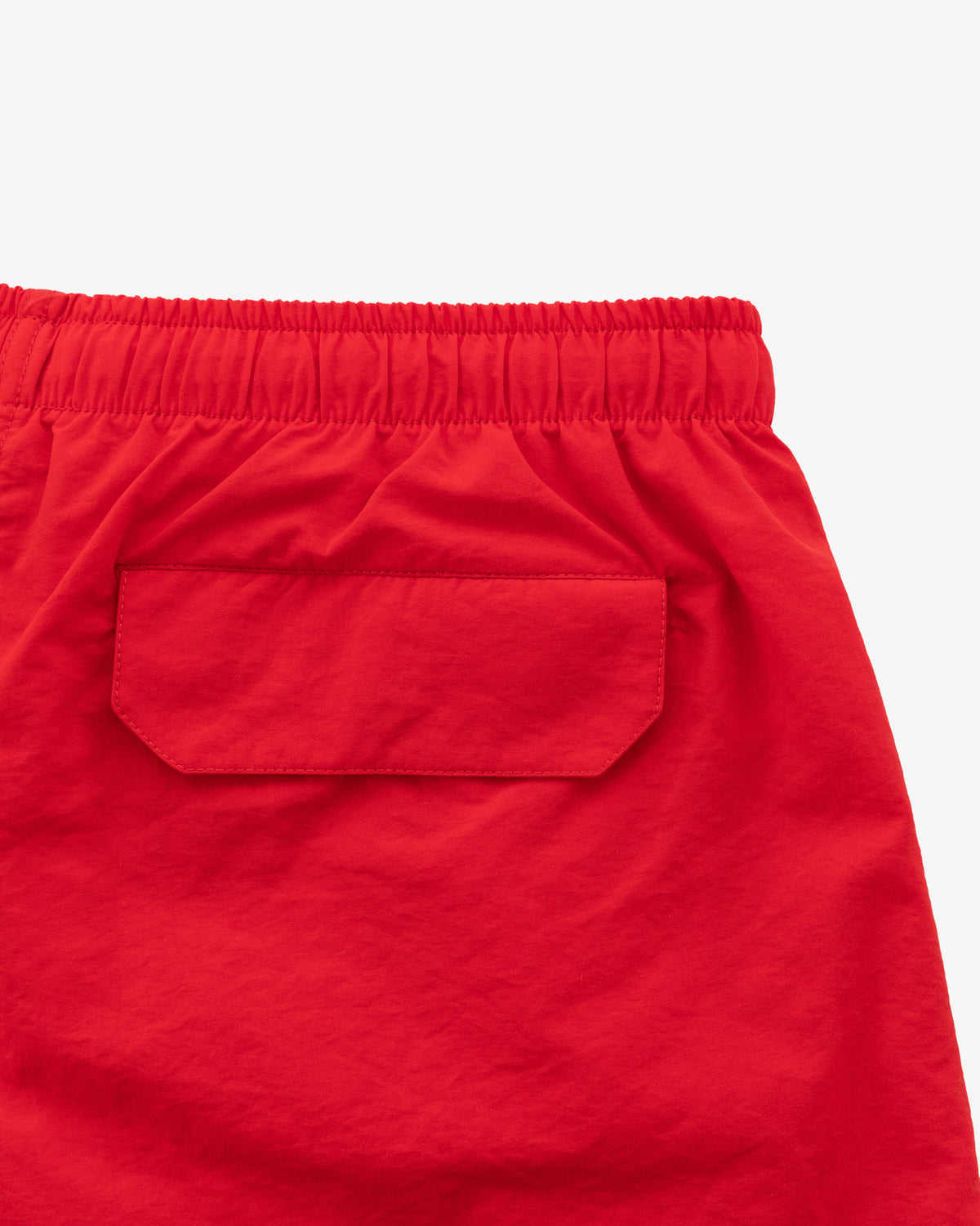 Close-up of Logo Swim Short in red with elastic waistband and back flap pocket.