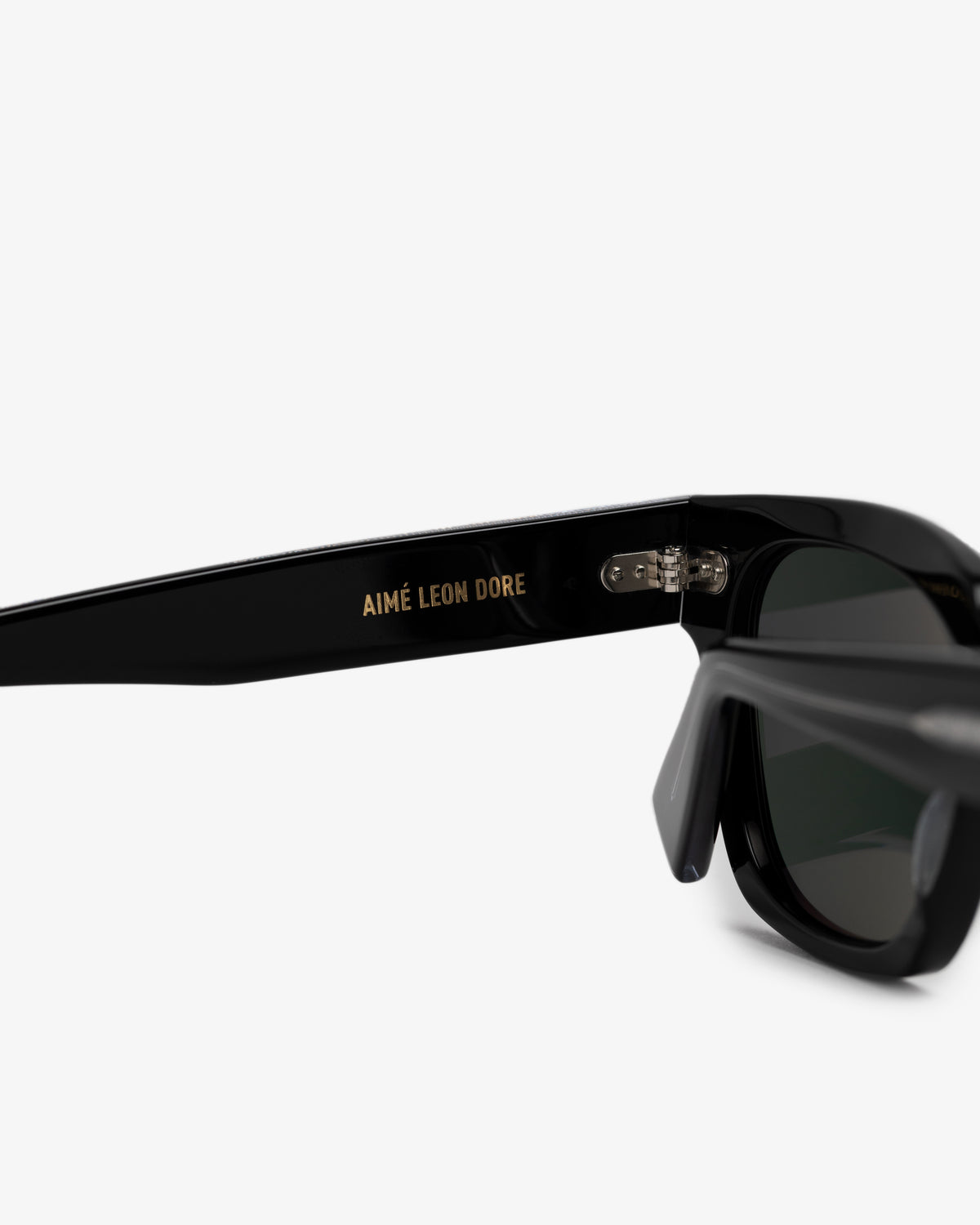 Close-up of Gallo Sunglasses with AIMÉ LEON DORE in gold on the arm, set against a white background.