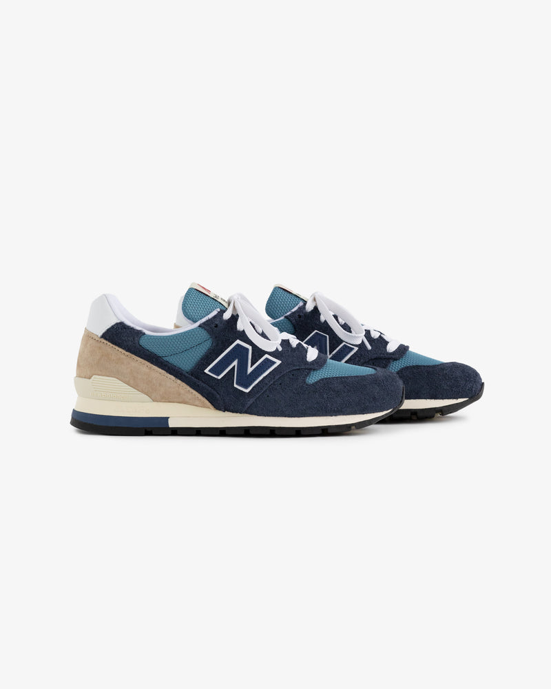 New Balance Made in USA 996 sneakers in blue, teal, and beige with white laces, viewed from the side.