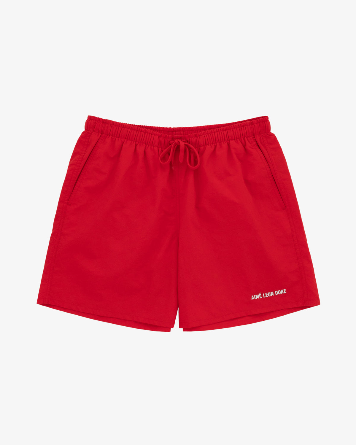 Logo Swim Short in bright red with elastic waistband, drawstring, side pockets, and AIMÉ LEON DORE text on the left leg.